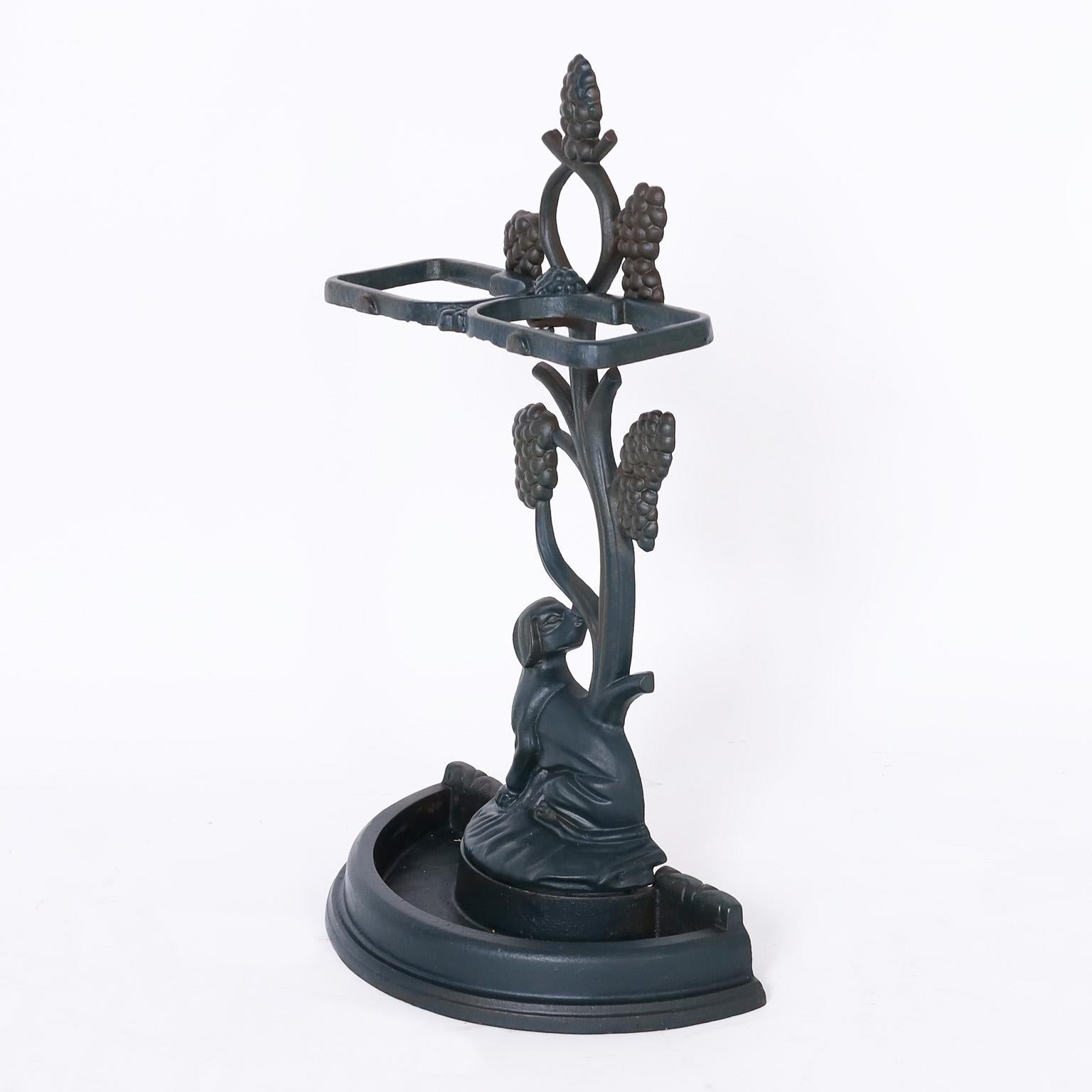 Charming antique English umbrella stand cast in iron with a top bracket supported by a stylized tree over a hunting dog with a water tray.