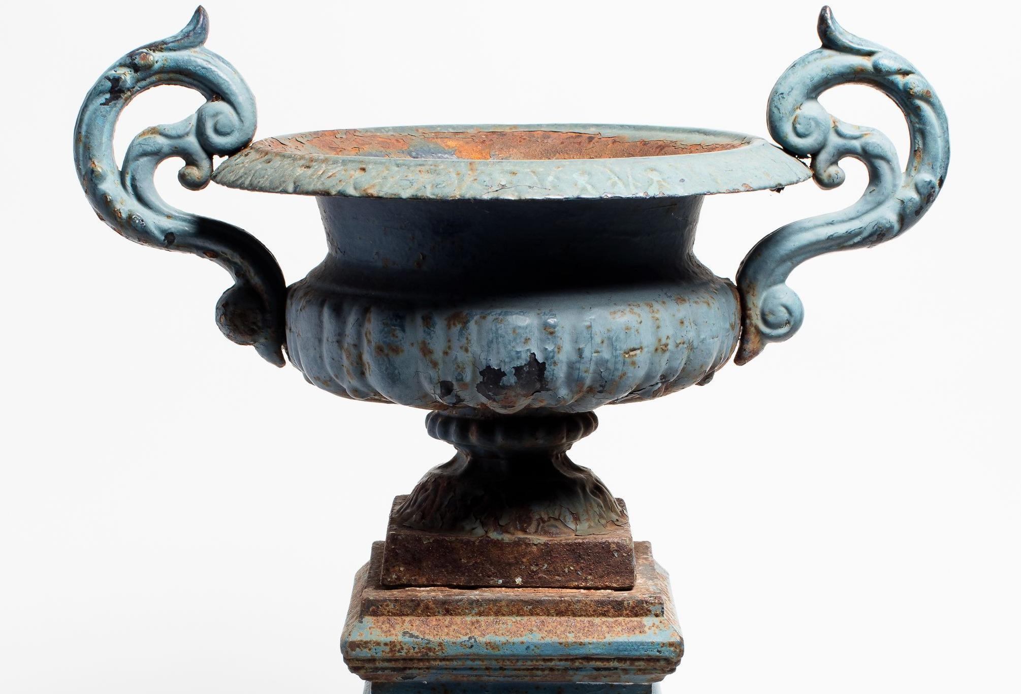 Neoclassical cast iron pedestal urn on plinth base, made in France circa 1880. Striking blue enamel finish with a patina from age and weathering. This traditional garden element is ideal for elevating greenery for a beautiful landscape. Discovered