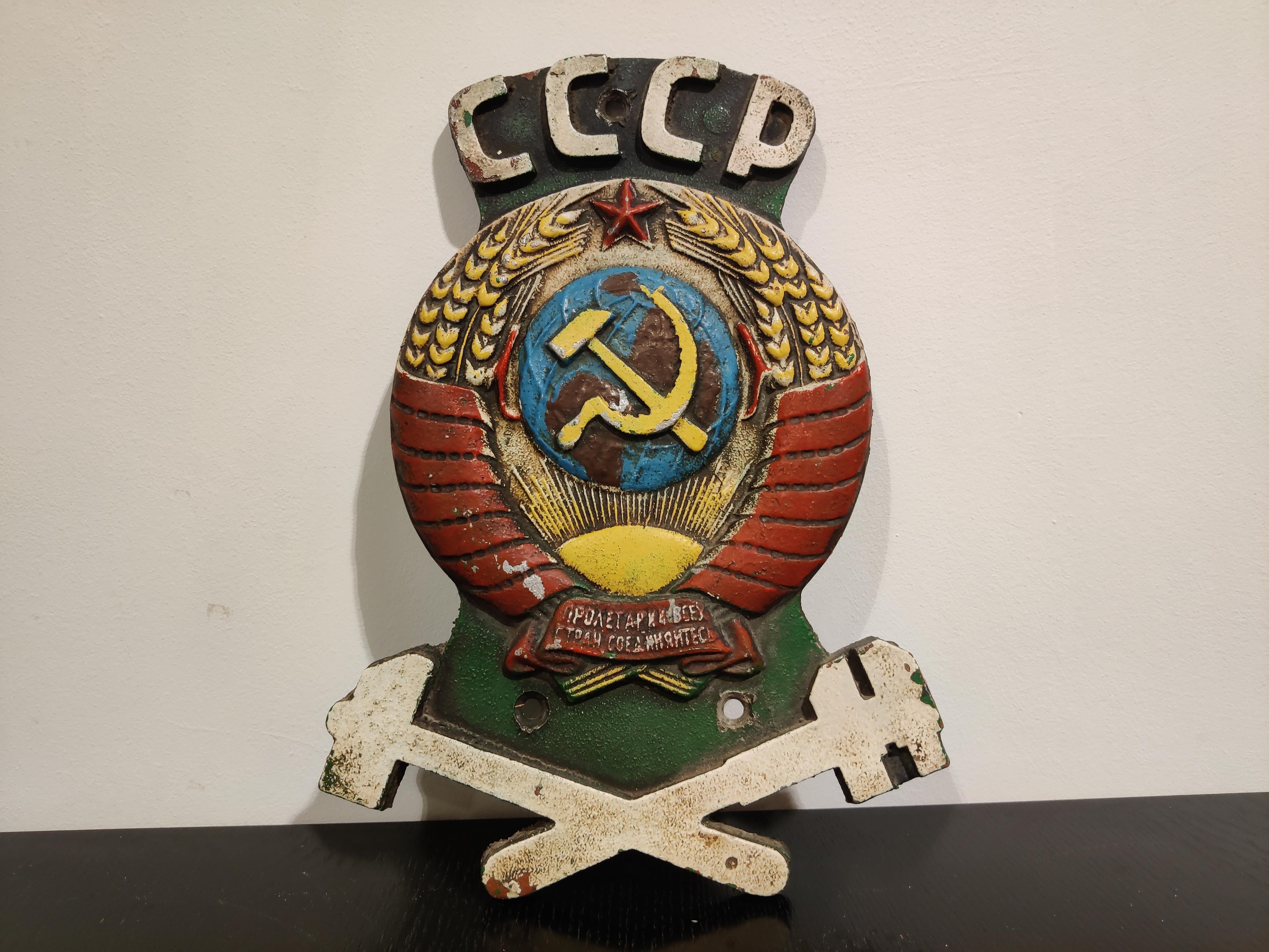 This rather extraordinary cast iron USSR sign was salvaged from a Russian train. 

A decorative piece with a statement...

It says CCCP which stands for USSR.

The worn but still visible colors and the detailed logo make this an interesting