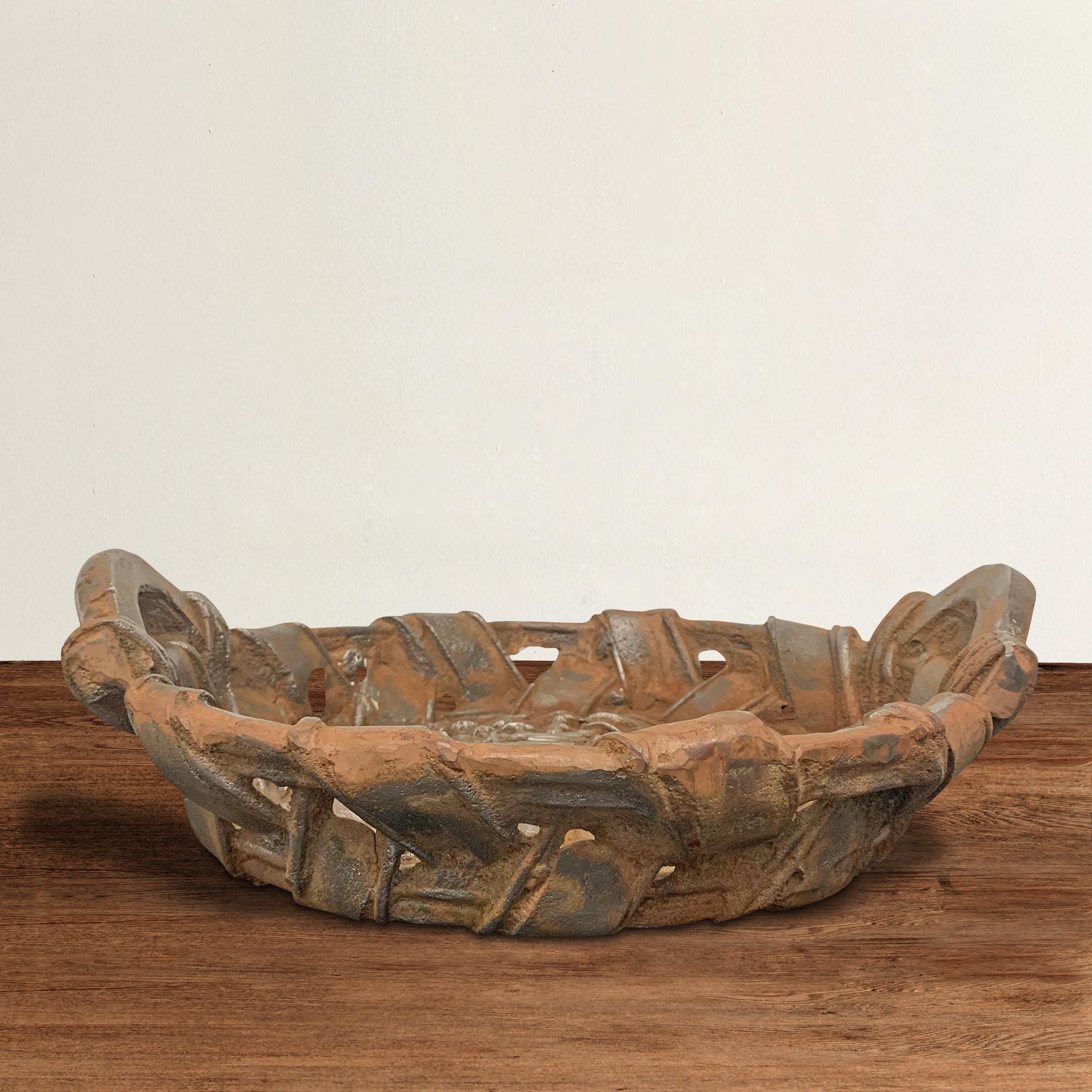 A chic yet unpretentious artist-made one-of-a-kind cast iron basket with a quirky tongue-in-cheek ironic disposition and an incredible patina.