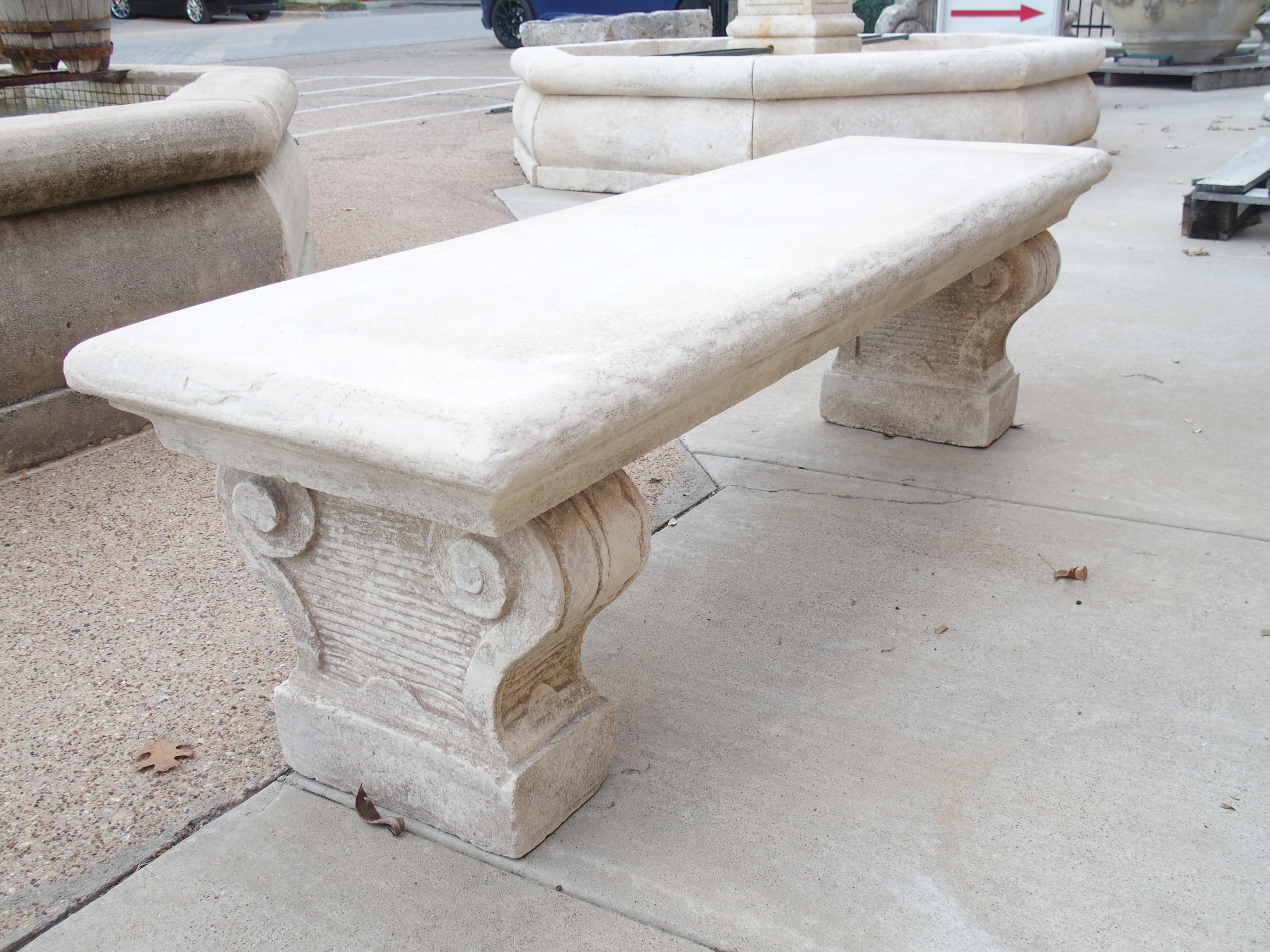 Consisting of reconstituted limestone, this garden bench was cast in Southern Italy. All three pieces of stone have a cream-colored finish with areas of white accents. The four-inch thick seat has been given a cavetto molding on all four sides,