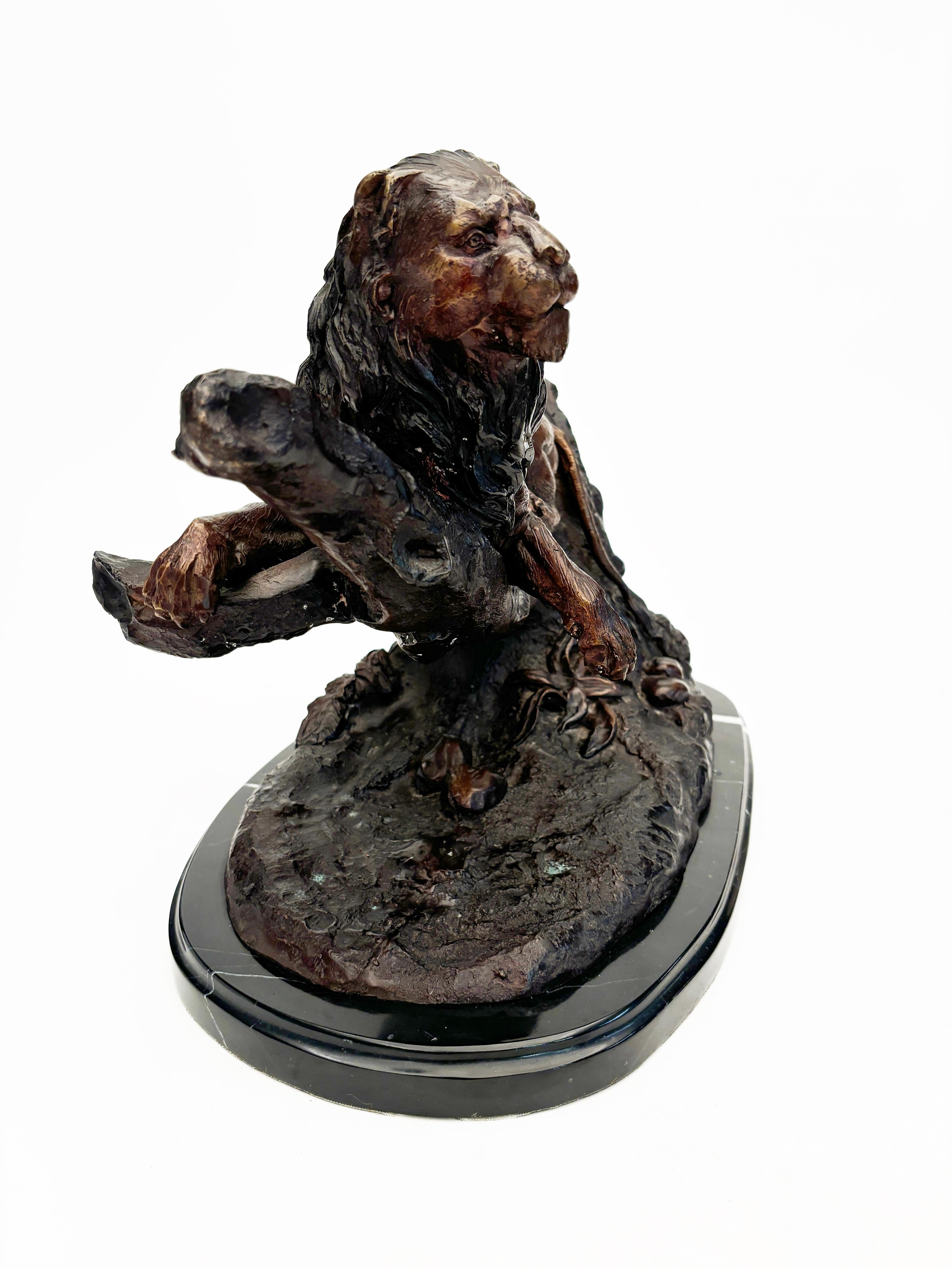 Cette sculpture complexe représentant un lion stoïque au repos sur une branche est magnifiquement moulée avec une patine caramel riche et foncée. Monté sur un socle en marbre noir qui soutient magnifiquement et structurellement ce superbe animal. 