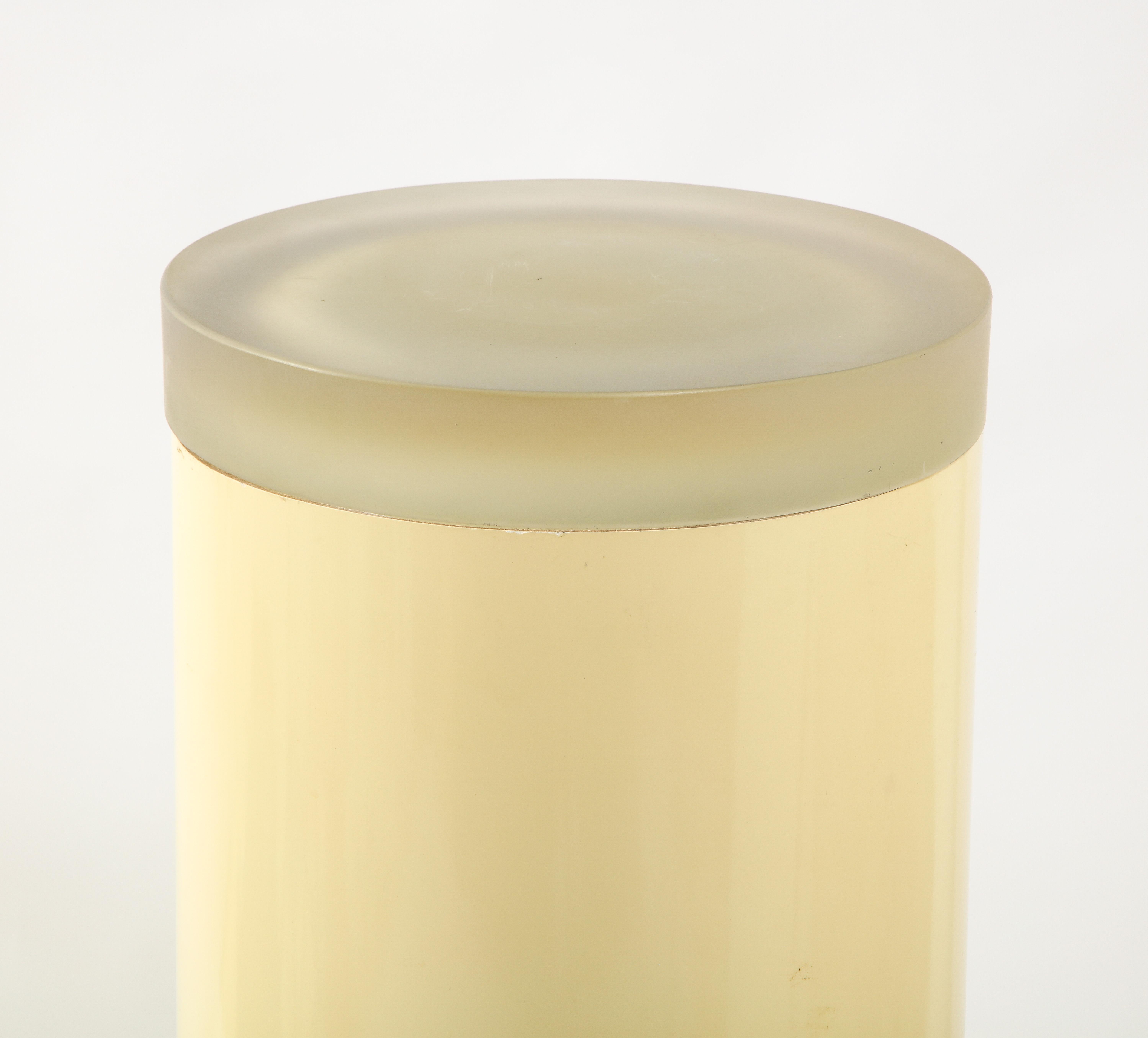 Round acrylic pedestal with a cast resin top, the light concealed within the pedestal makes the resin glow warmly. It can be used to display art or as an accent light.