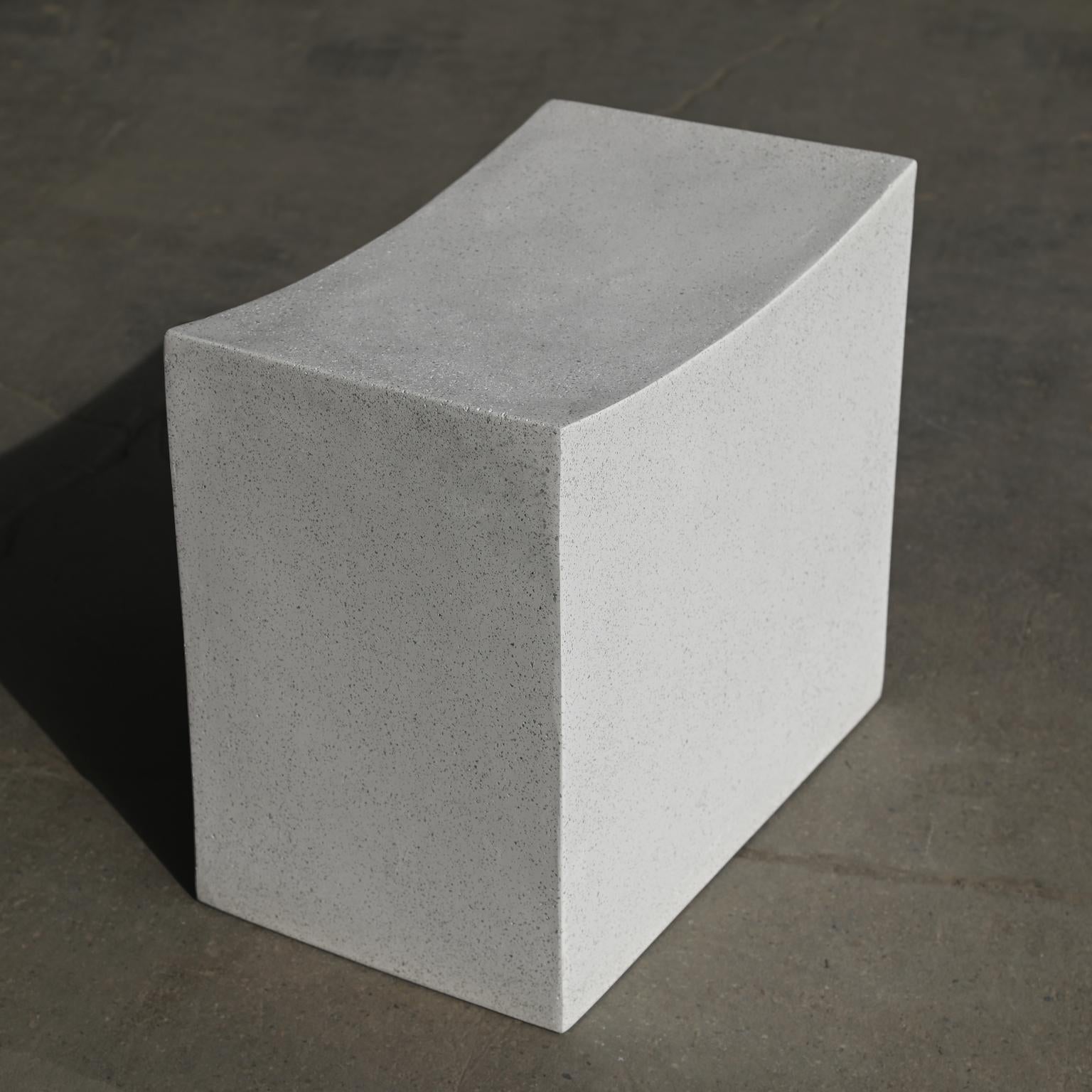Sensibilità brutalista con un'accoglienza rilassante e gentile. Questo blocco di sostegno è stato scolpito in un arco dolce, con una pietra che attraversa la sua corona. La geometria rigida si piega e diventa organica, ricordando il potere di