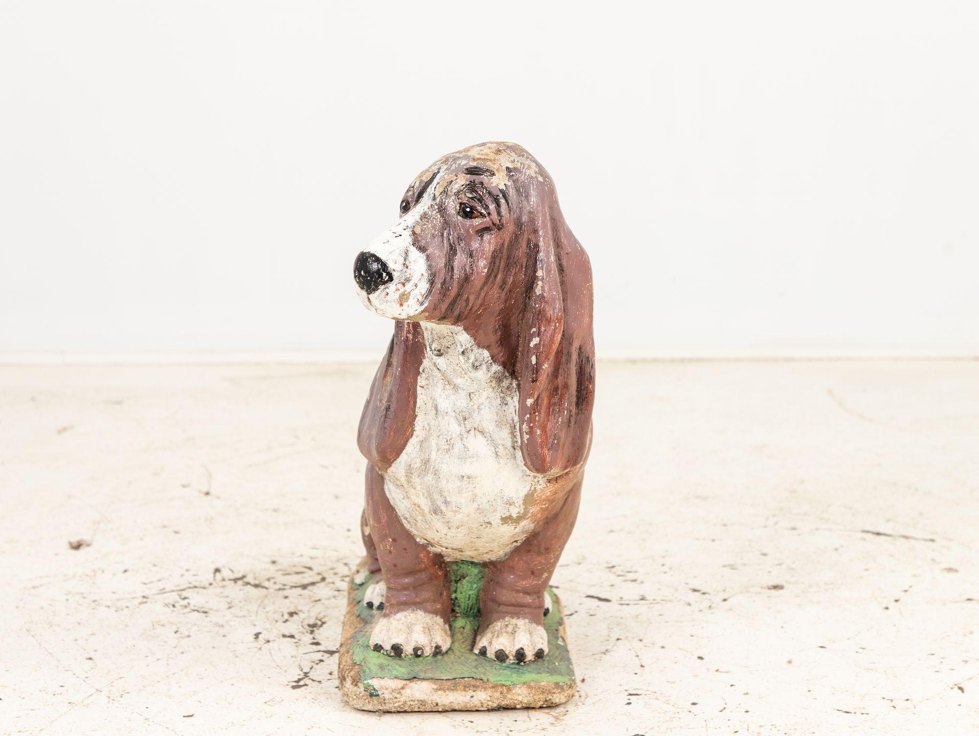 This charming hound dog garden ornament boasts a captivating patina that has gracefully aged over time retaining some paint. Despite minor imperfections, it holds its original form beautifully. The enchanting patina has added charming green accents