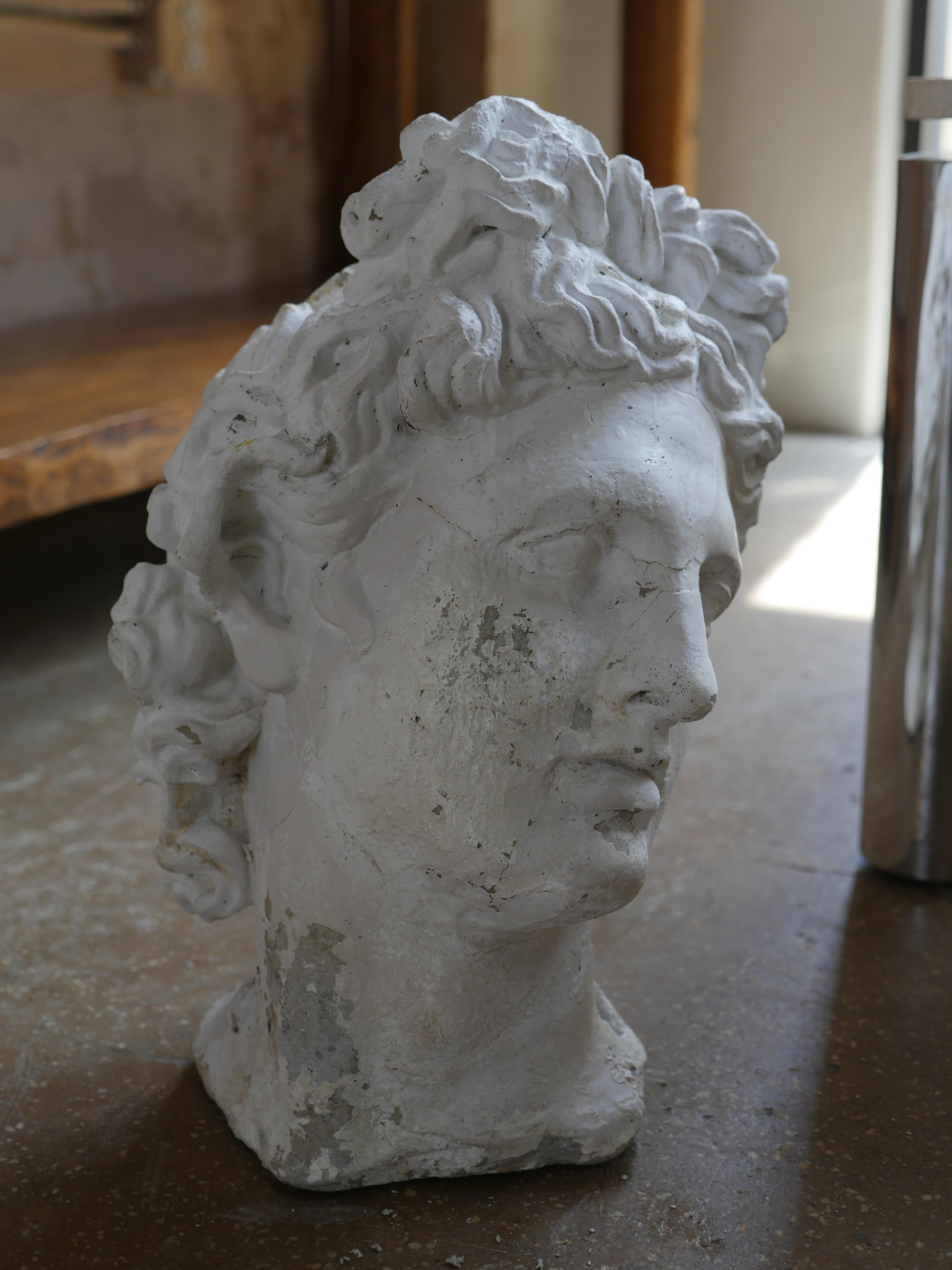 This vintage 1980s cast stone bust is a beautiful representation of Apollo Belvedere, with intricate detail and lifelike features that capture his essence. This piece would make a stunning addition to any room styled on a pedestal, credenza or table.