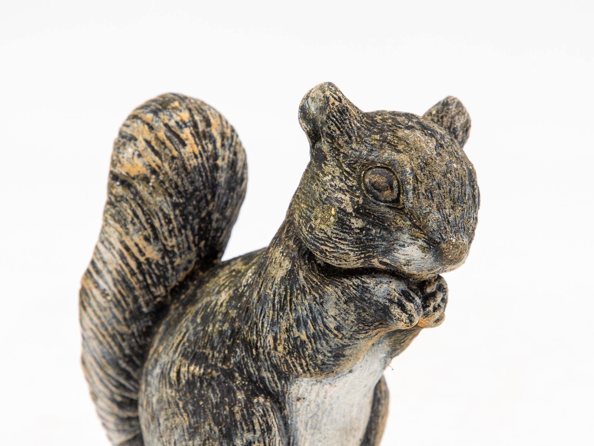 

Introducing a delightful mid-20th century cast stone squirrel garden ornament, exuding a charming sense of nostalgia that adds a touch of whimsy to any outdoor space. This enchanting figurine, crafted from durable concrete, captures the essence of