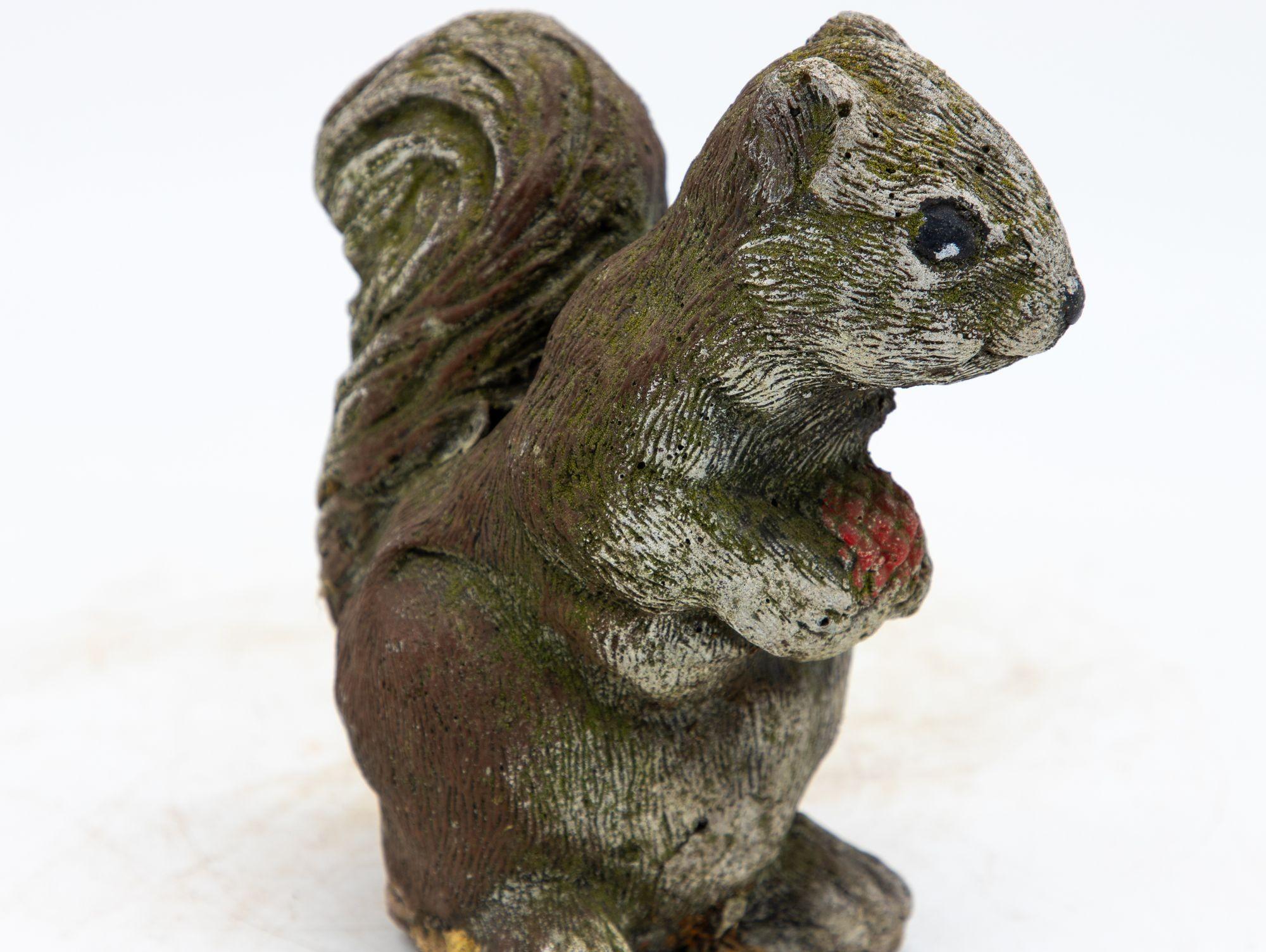 This delightful mid-20th century cast stone squirrel garden ornament, exudes a charming sense of nostalgia that adds a touch of whimsy to any outdoor space. This enchanting figurine, crafted from durable concrete, captures the essence of a curious