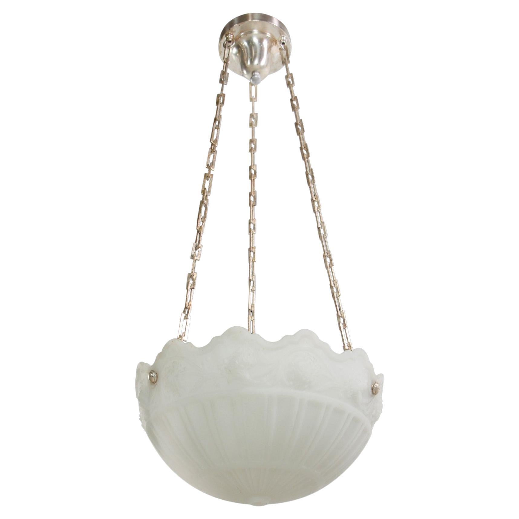 Early 20th century white cast glass dish pendant light with ornate embossed details and featuring the original silver plated brass chain. Replacement nickel plated canopy. This light is original to a Philadelphia mansion. Please note, this item is