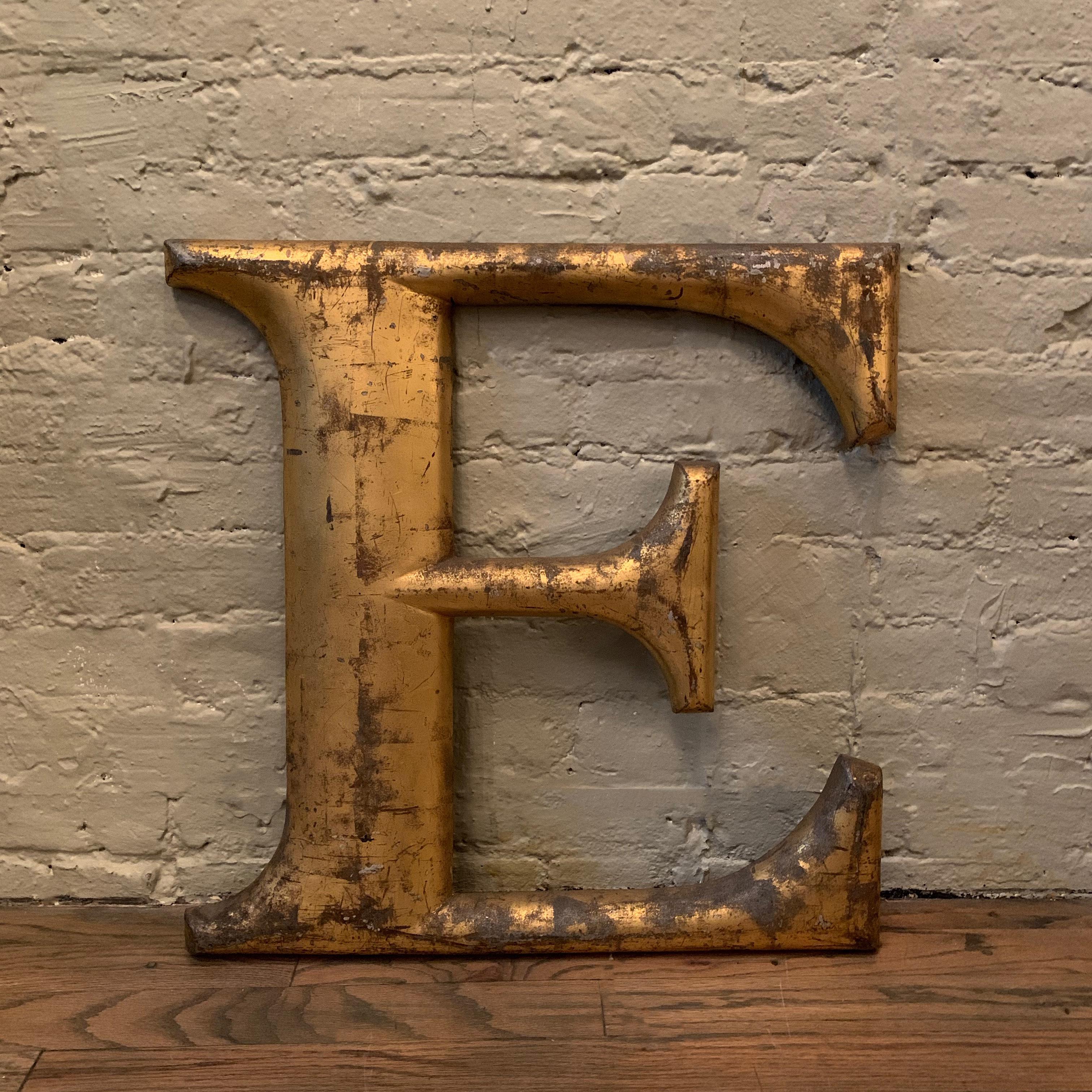 Cast zinc aluminum alloy, marquee letter E, features a painted gilt surface with its wonderful, weather-worn, original patina.