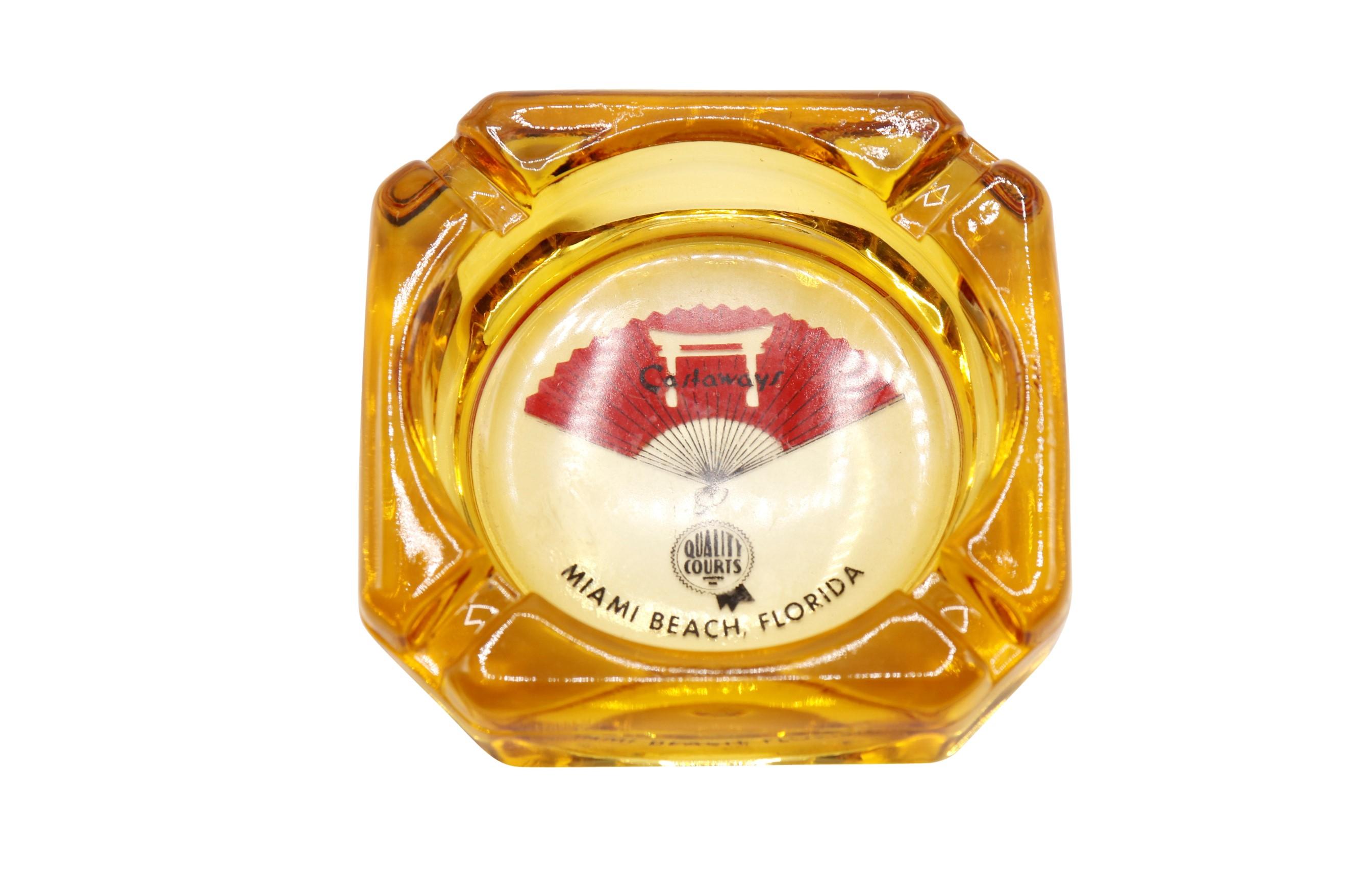 A pair of yellow glass ashtrays from The Castaways Hotel of Miami Beach, Florida. The center is printed with their logo and reads “Castaways, Quality Courts, Miami Beach Florida”. Dimensions per ashtray.
