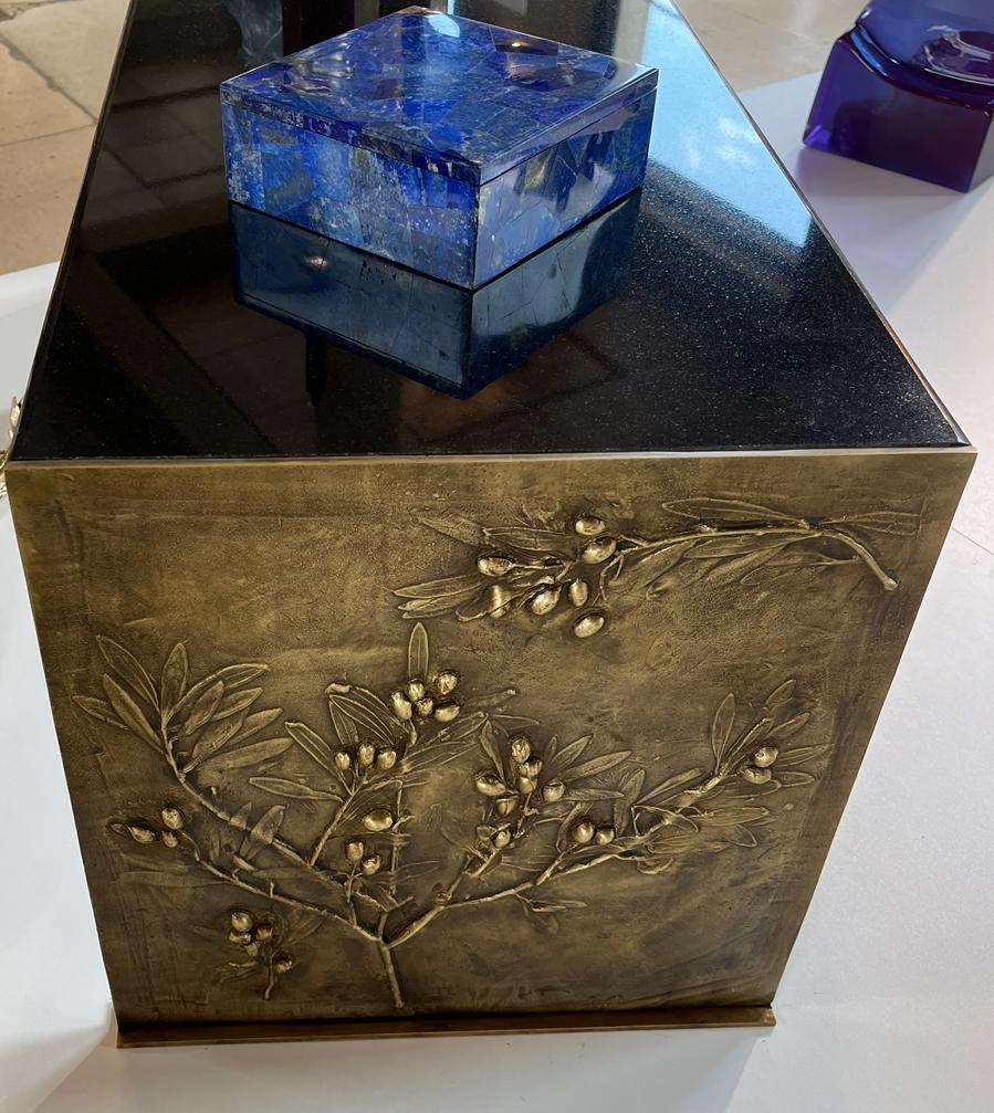 Élevez votre espace de vie avec cette exceptionnelle table basse en édition limitée (1/8), véritable fusion entre l'art, la nature et l'artisanat. La base est coulée à la main dans un laiton noirci profond, sculpté de motifs complexes de branches