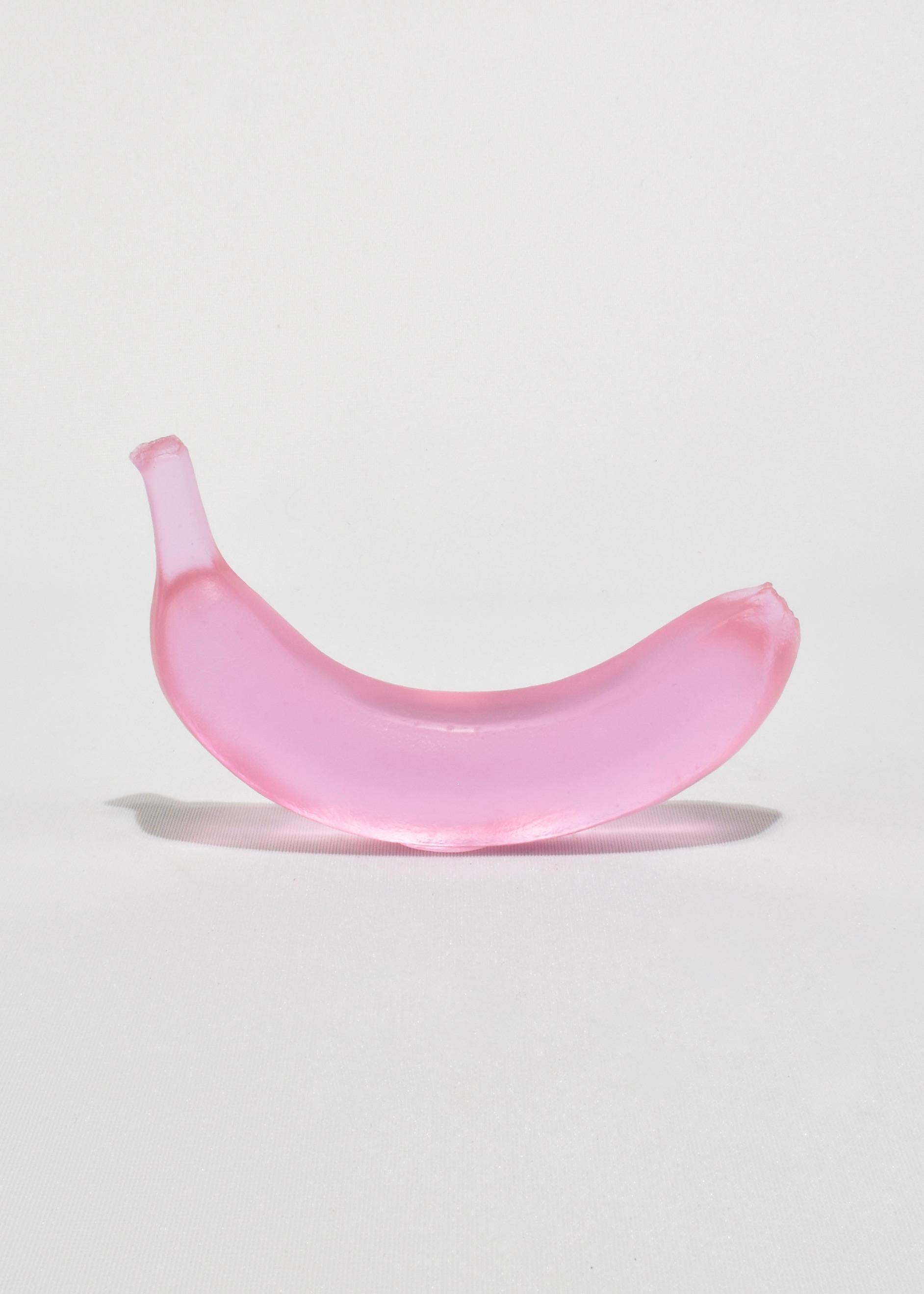 Casted glass banana in dichroic lilac by Devon Made inspired by blown glass fruit makers and collectors from the 1960's. The light playful approach to everyday fruit is contrasted with the heaviness of the crystal glass, a unique material that