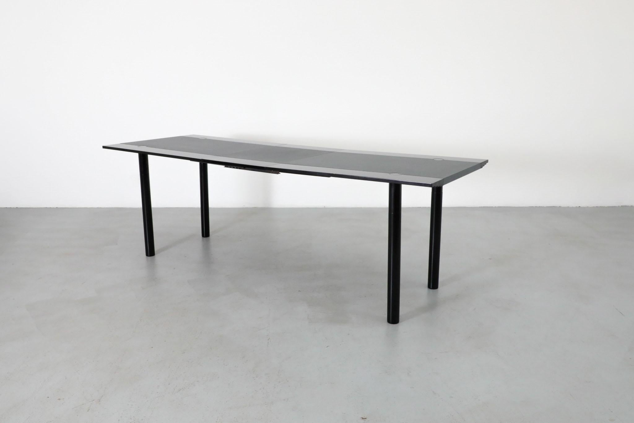 Table de salle à manger de style Sotsass Modèle TA180 en bois laqué noir avec panneau central en Formica imprimé gris, gros pieds ronds et rallonge. Conçue pour Castelijn dans les années 1980 et attribuée à Louk Straver, cette table présente un