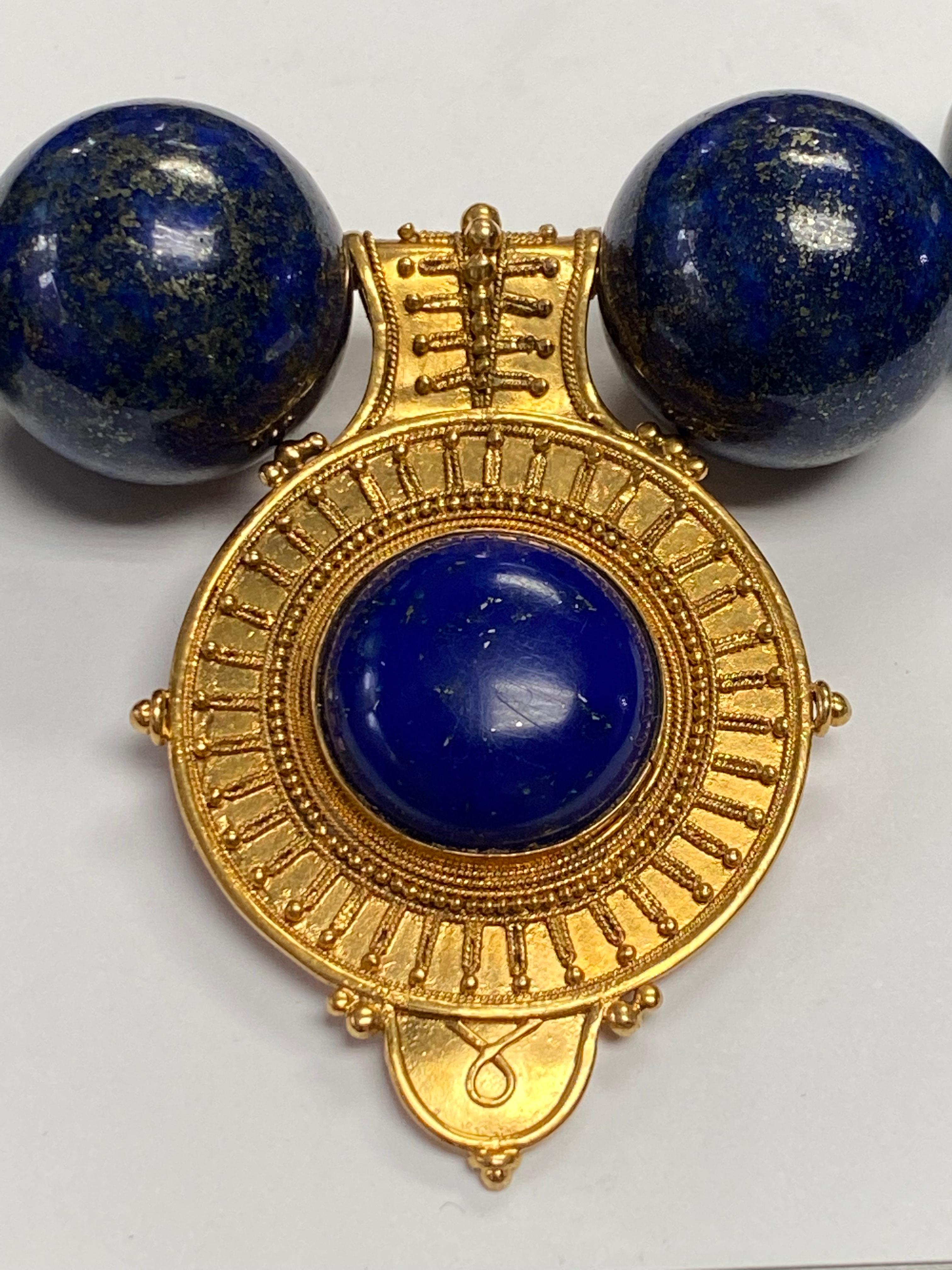Etruscan style 18kt yellow gold bulla centered by a low dome cobalt blue cabochon lapis. The gold granulation was hand applied, each wire and bead one at a time. The process of gold granulation was created in Ancient Mediterranean civilizations.