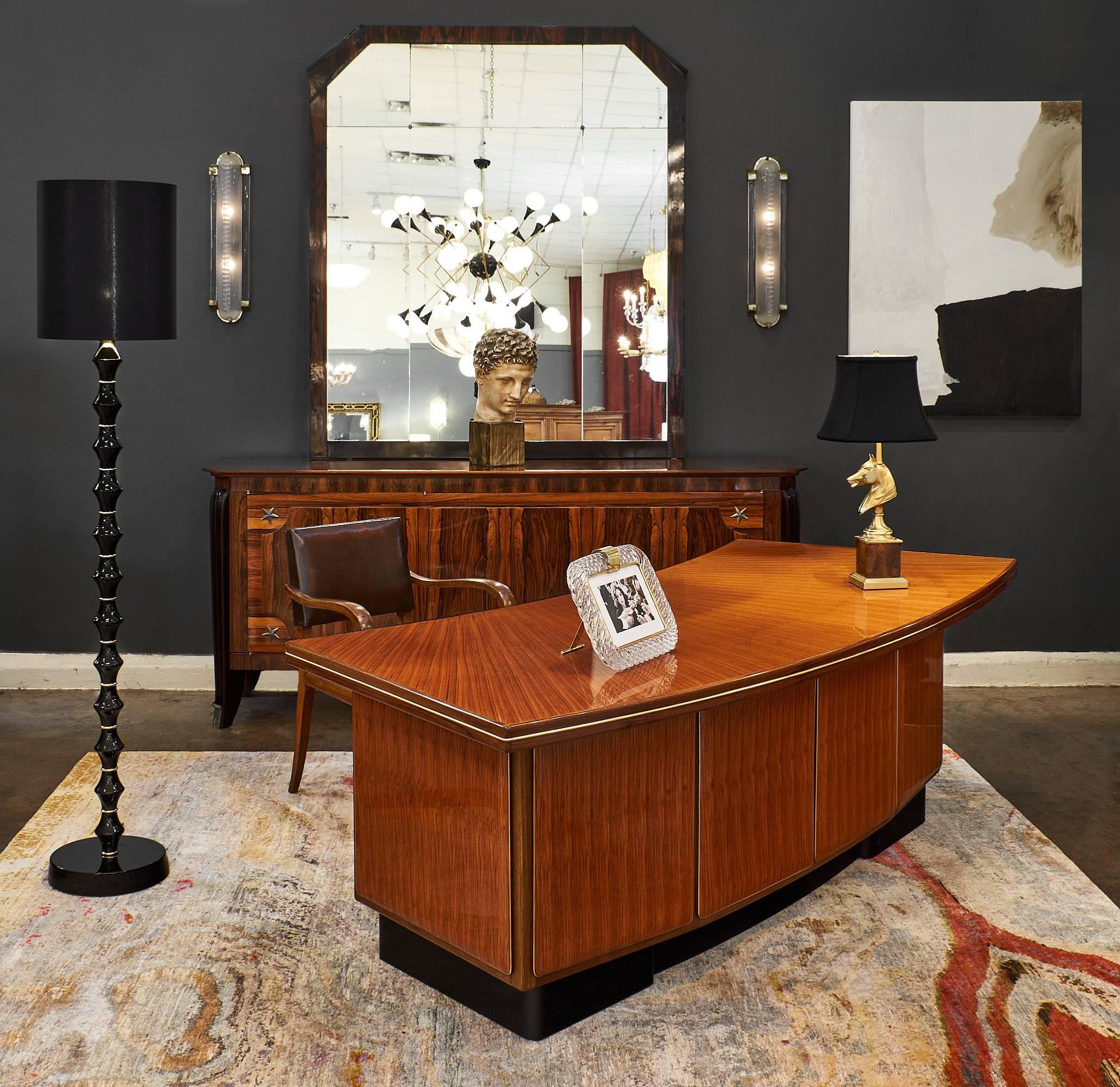 A presidential midcentury desk by Castelli made of rosewood and finished with a lustrous polish. This piece has ample storage. Castelli is a famous design and furniture company created by Ettore Castelli. They have received three Golden Compass