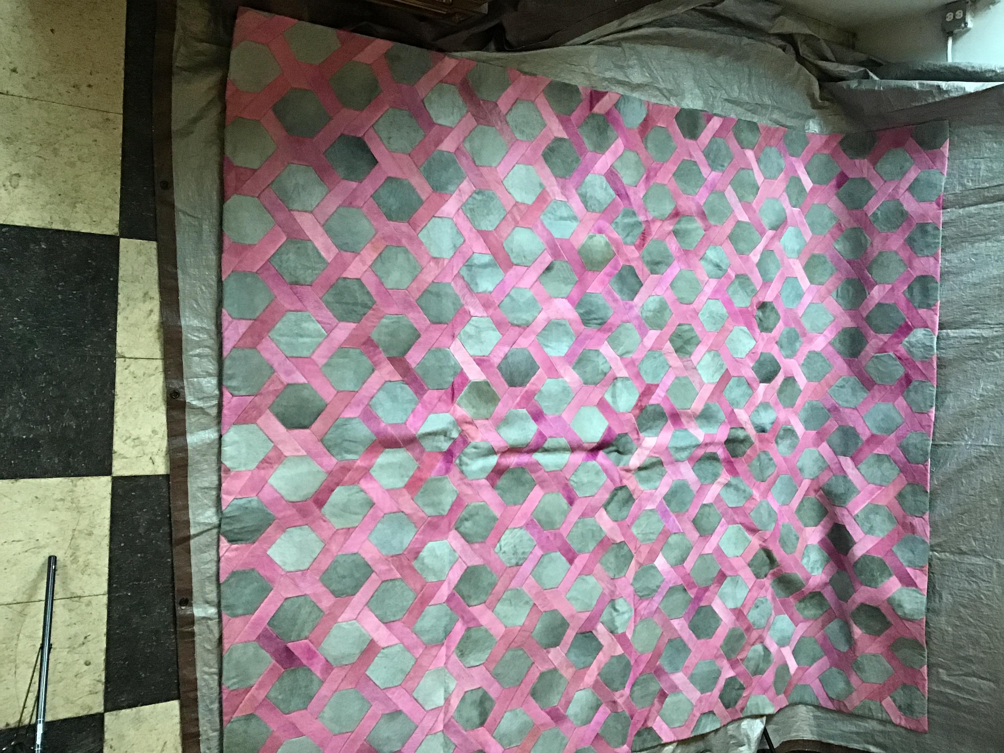 Castelluxe pink, grey, hair on hide rug. 8 x 10. Interlace design.