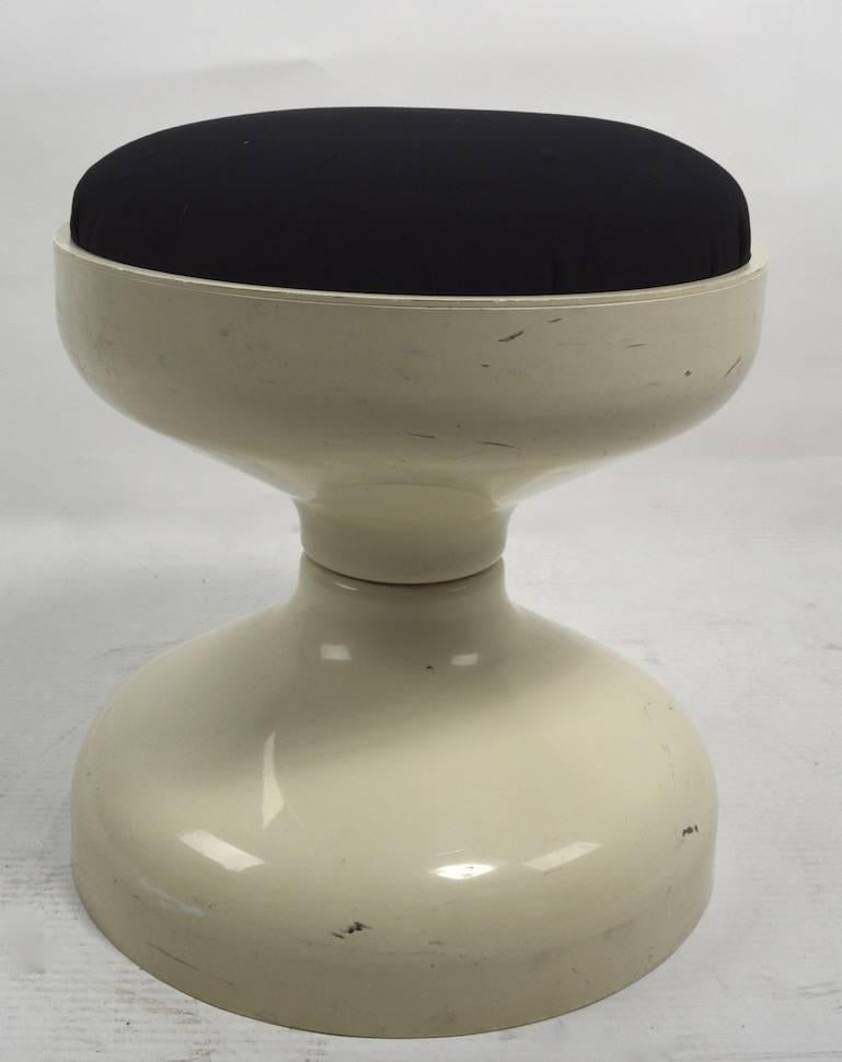 Known as the Rocchetto, or Spool Stool, this piece was designed by Castiglioni for Kartell, circa 1960s. Hard plastic off-white color base supports black fabric upholstered top. Base shows some cosmetic wear, notably scuffing, as shown. No