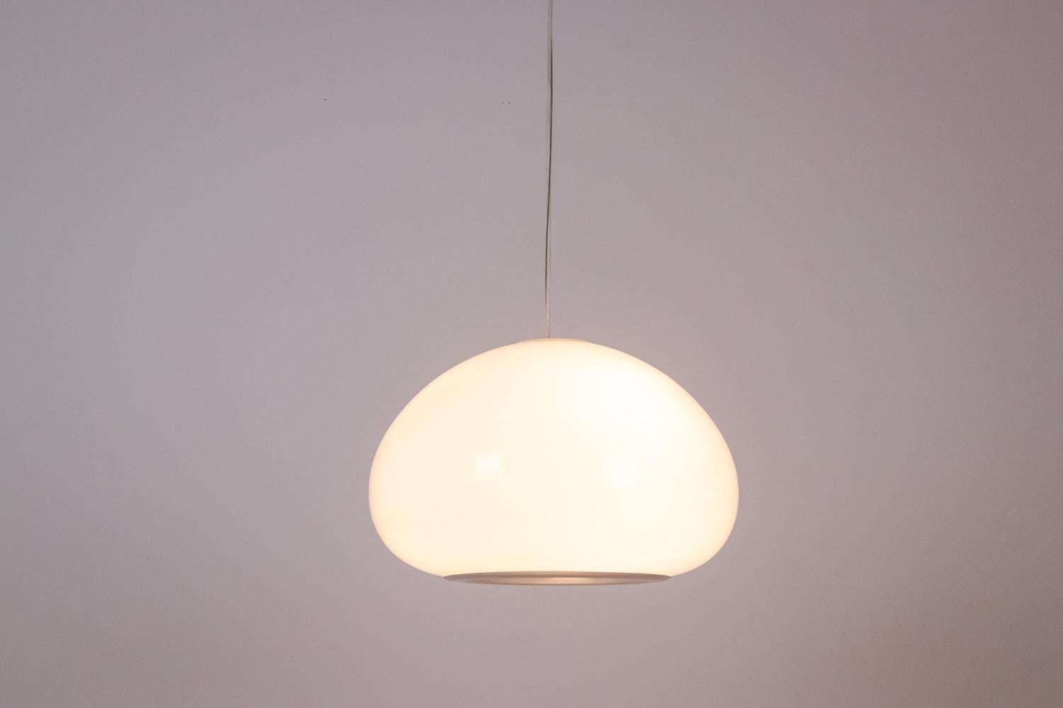 Achille & Pier Castiglioni, by.
Flos, edited by.

Pair of pendant lights. Each pendant light is made up of a white opaline with concentric circles in chrome metal in its center, circular in shape, the opaline being held by a stem and a white cup,