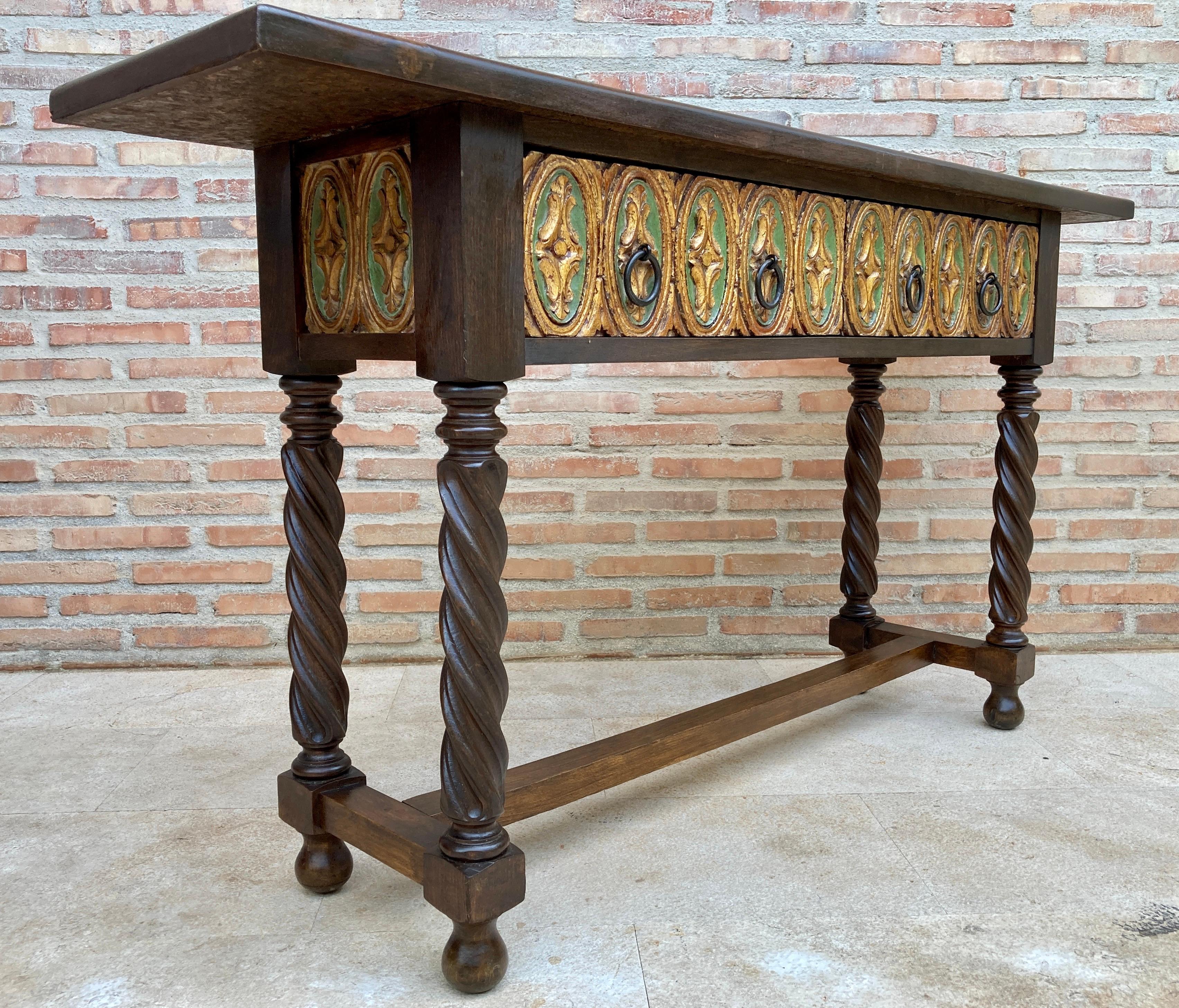 Castilian mid century console table in walnut with two front drawers in gold leaf. 
Beautiful console in walnut and gold leaf, with an original mid-century style from the 40s. 
It has two large drawers with iron handles. 
The console stands on