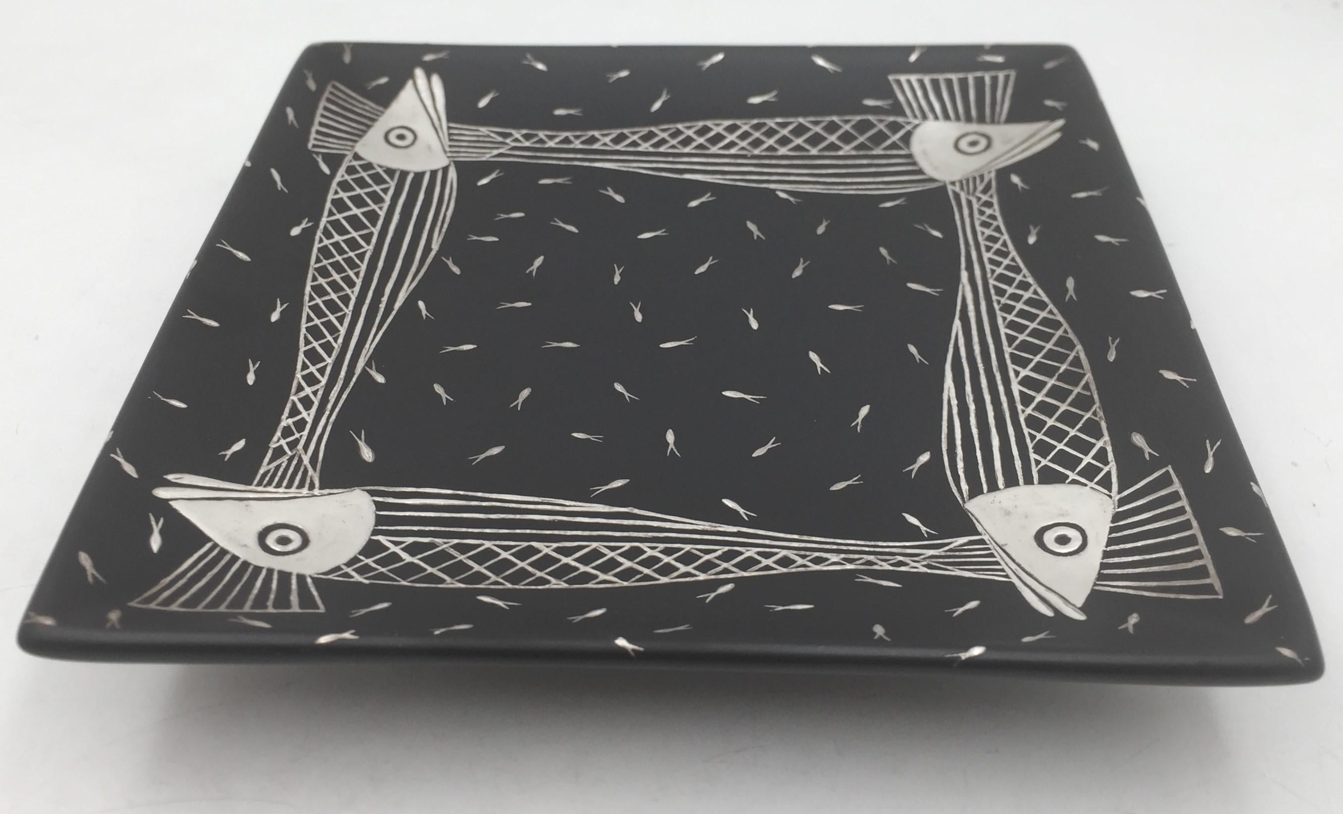 Emilia Castillo Mexican square black ceramic dish with inlaid, sterling silver fish motifs in Mid-Century Modern style with a beautiful geometric design, standing on a base. It measures 9'' in length by 1 7/8'' in height, and bears hallmarks as