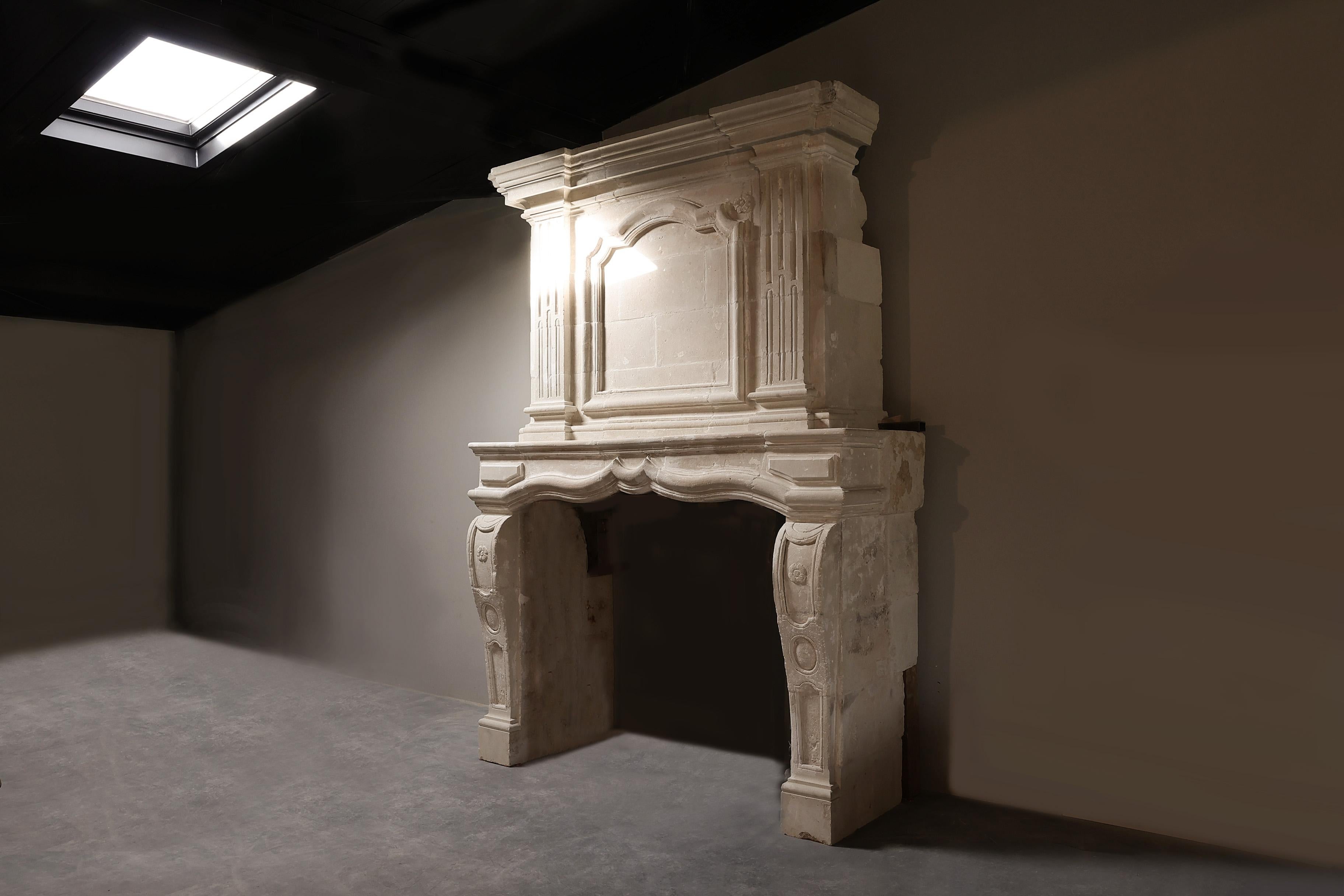 Beautiful antique castle fireplace of French limestone from the 19th century. This mantle with trumeau is richly decorated with ornaments and beautiful lines. A fireplace with a stately and robust warm appearance. An added value for your interior!