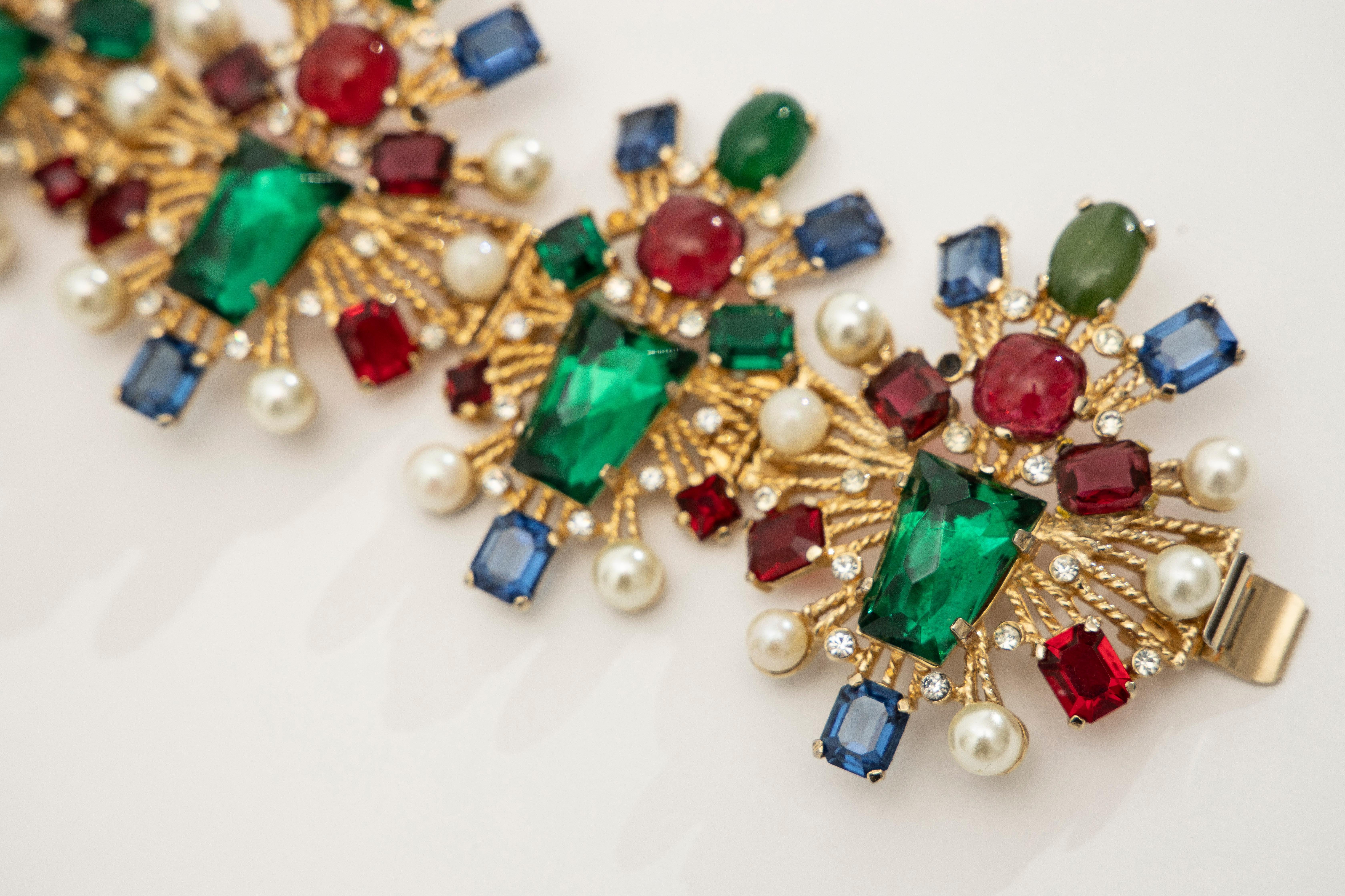 Castlecliff, Circa: 1950's gold plated multi-color glass cabachon & faceted glass link bracelet with small crystal & faux pearls and tongue box clasp closure.

Length: 7.5, Width: 2 3/4