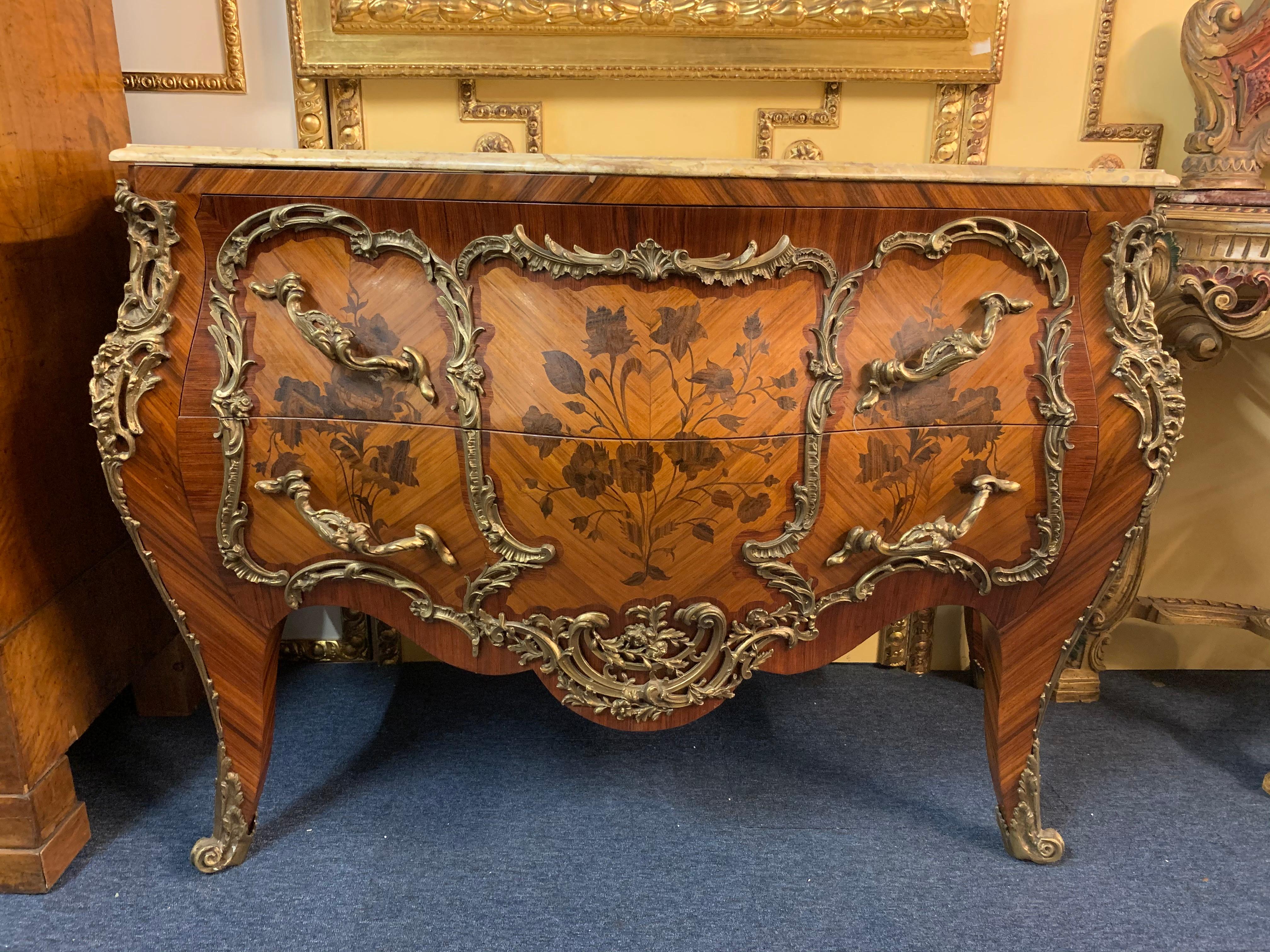 Shaded precious wood, veneered. In the front two drawers, in the front and on the side walls broadly framed fillings with richly inlaid blooms of different noble wood, limited by so-called mirror veneer. On the corresponding sides and in the front