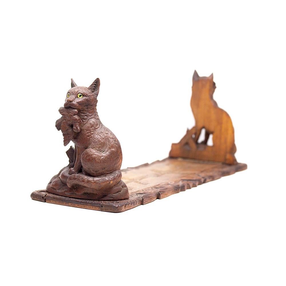 Antique late 19th century carved rare Black Forest extended cat book stand. The stand modelled as twin cats holding their pray at each side. Each end hinged at the base allowing the stand to be rested flat for storage. The stand extends through the