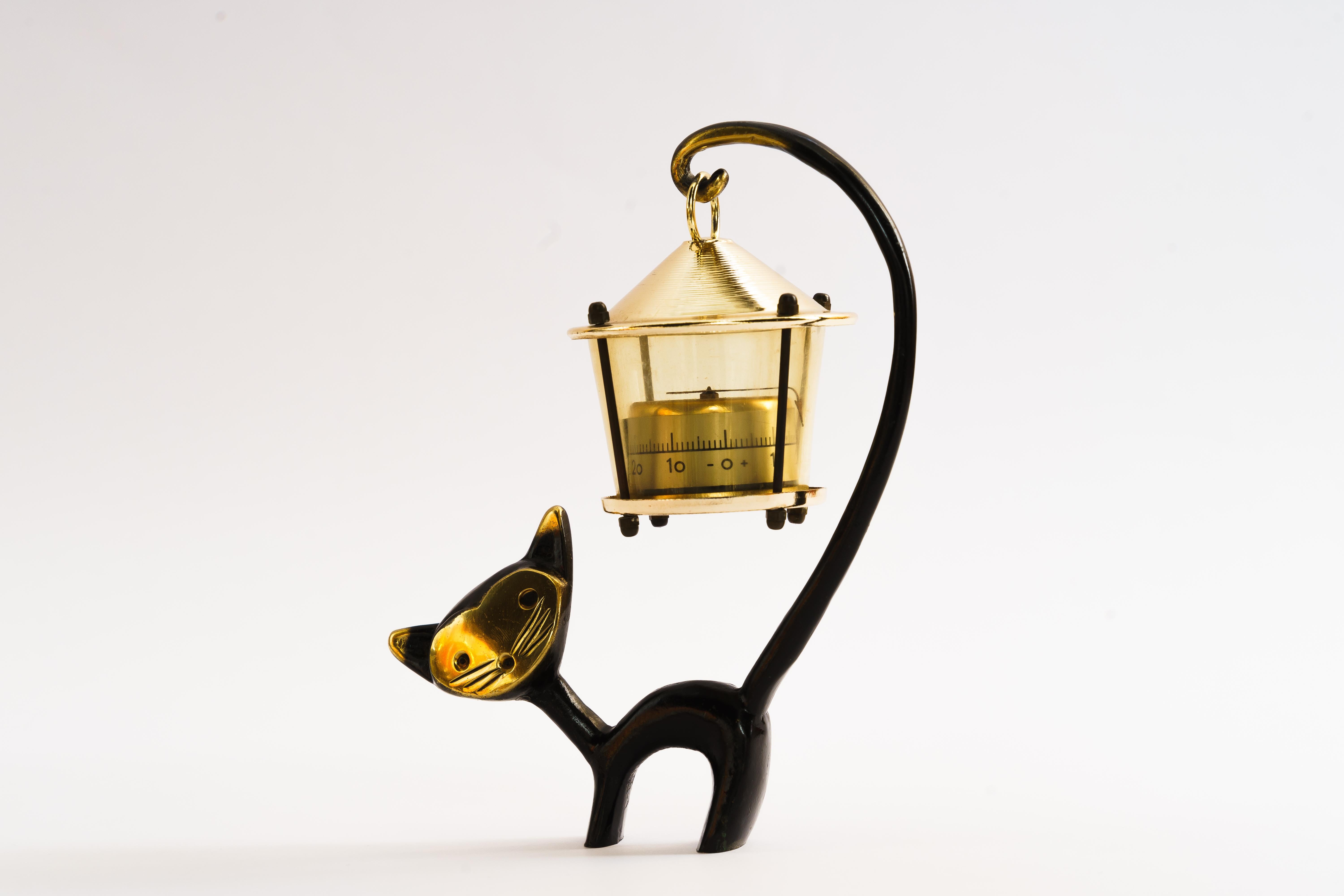 A very charming Austrian desk thermometer, consisting of a nice cat figurine and a lantern-shaped thermometer. 
A very humorous design by Walter Bosse, executed by Hertha Baller Austria in the 1950s. 
Made of brass, in good condition.