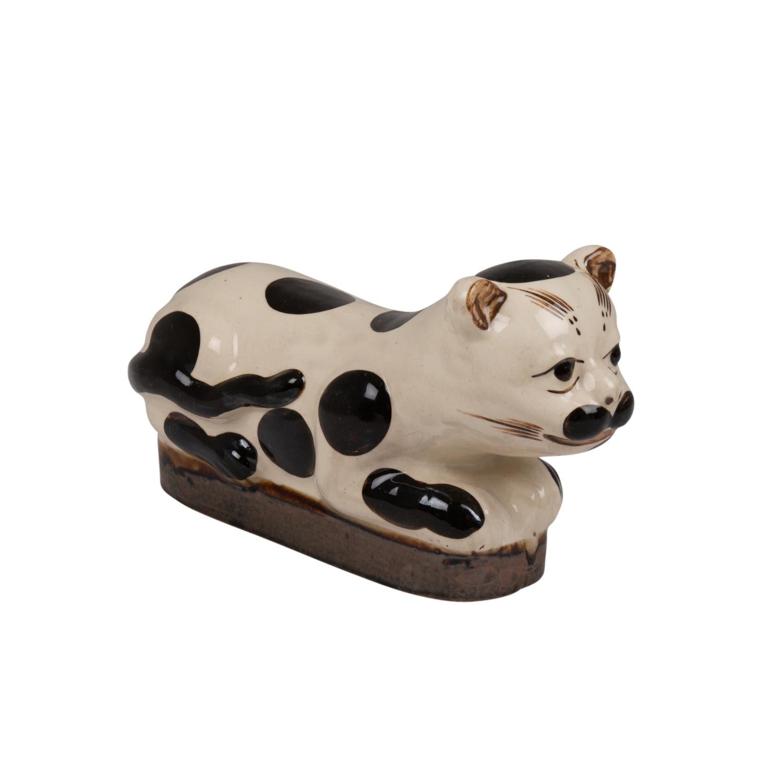 Ceramic representing a seated cat of rectangular shape and white and black, spotted.

Chinese work realized circa 1900.