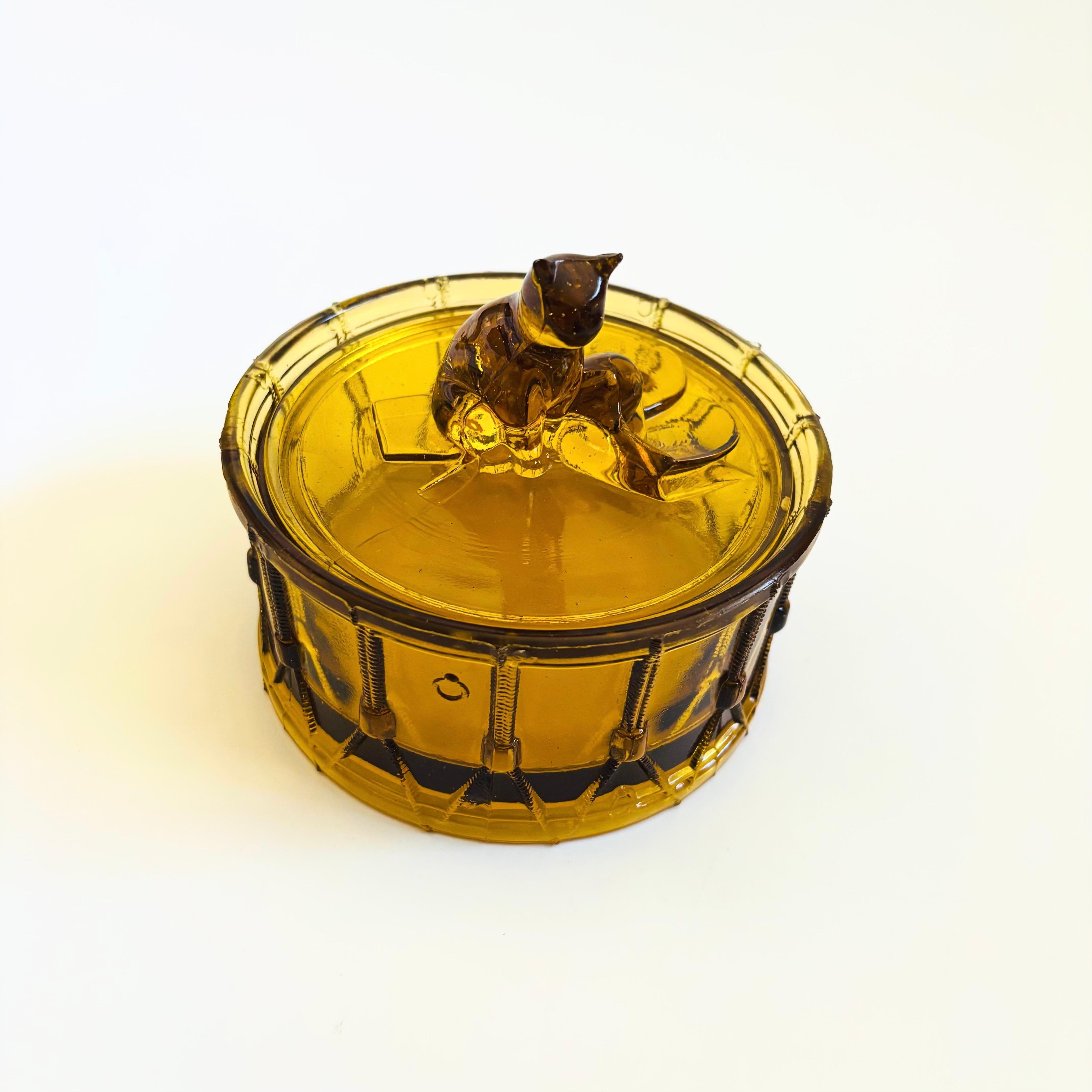 A vintage amber glass lidded box in the shape of a cat sitting on a drum. Made in France by Portieux Vallerysthal. Lovely detailing throughout. Marked 