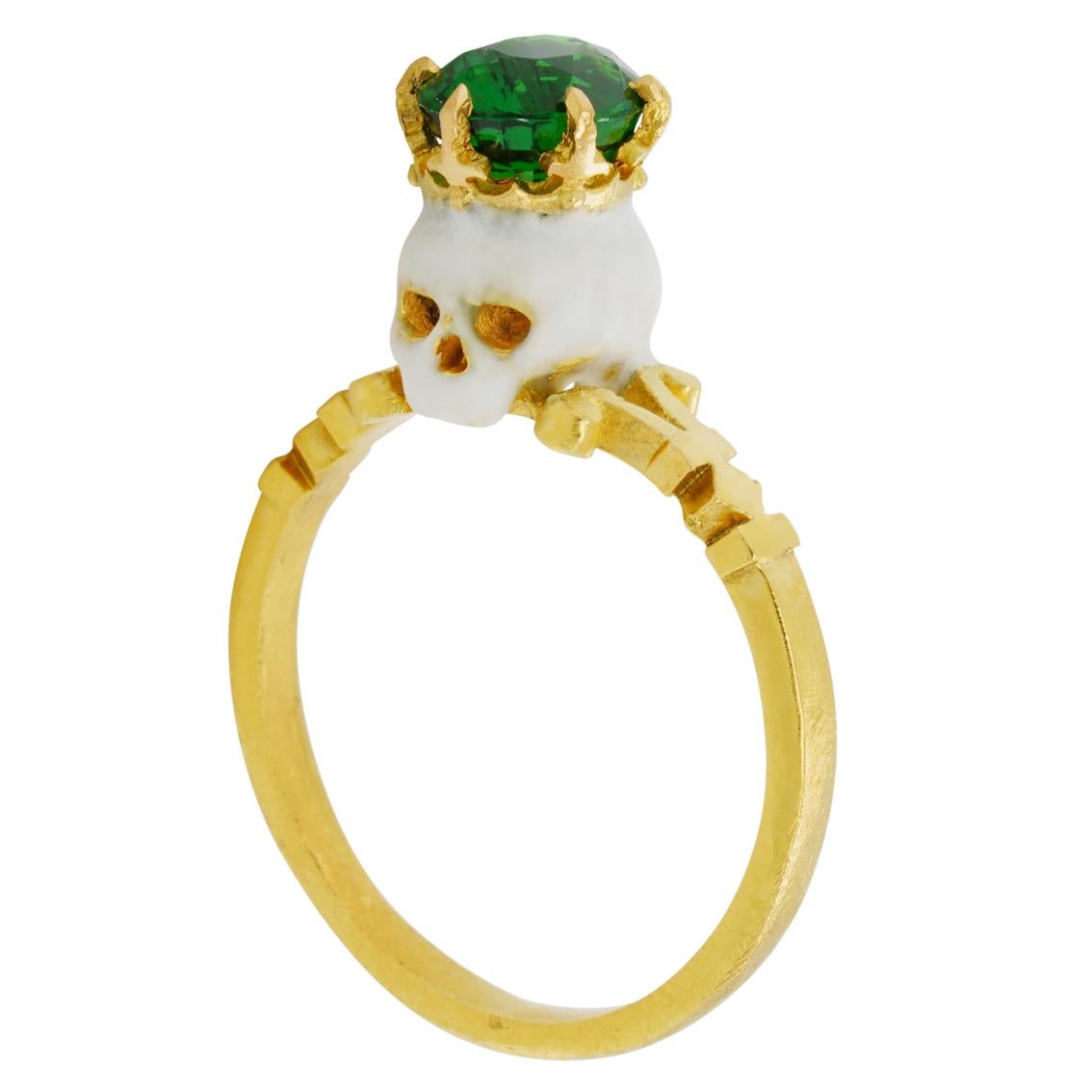 Handcrafted in luxurious 22kt yellow gold this stunning ring features a saintly baroque style enamelled skull adorned with a crown and hypnotic 7.4mm x 6.2mm 1.6ct Tsavorite garnet perched atop a signature William Llewellyn Griffiths split shank.