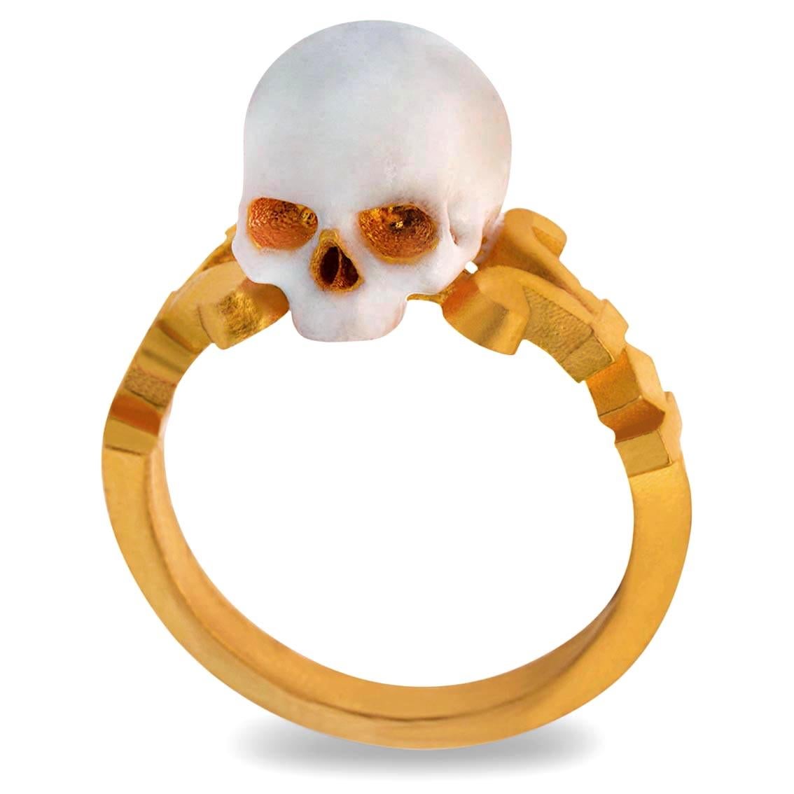 Handcrafted in luxurious 24kt yellow gold this stunning ring features a saintly baroque style enamelled skull perched atop a signature scrolled William Llewellyn Griffiths split shank. 

Measuring 9mm above the finger this sumptuous memento mori