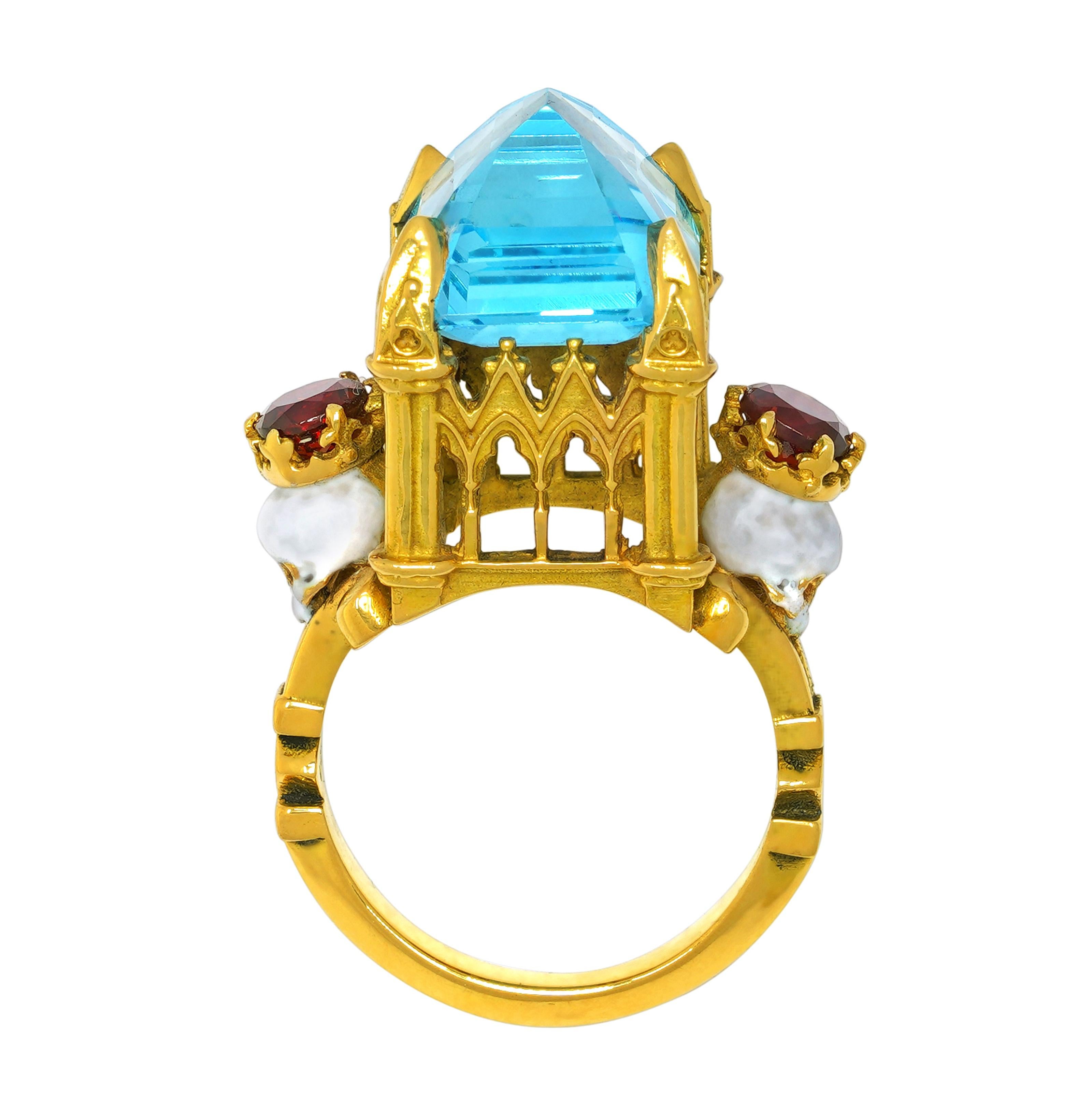 Handcrafted in 18kt yellow gold this hallowed ring features a deific central 15.7mm x 12.9mm x 9.5mm crisp blue topaz held aloft a signature William Llewellyn Griffiths cathedral setting and split shank. The heavenly central stone is flanked by two