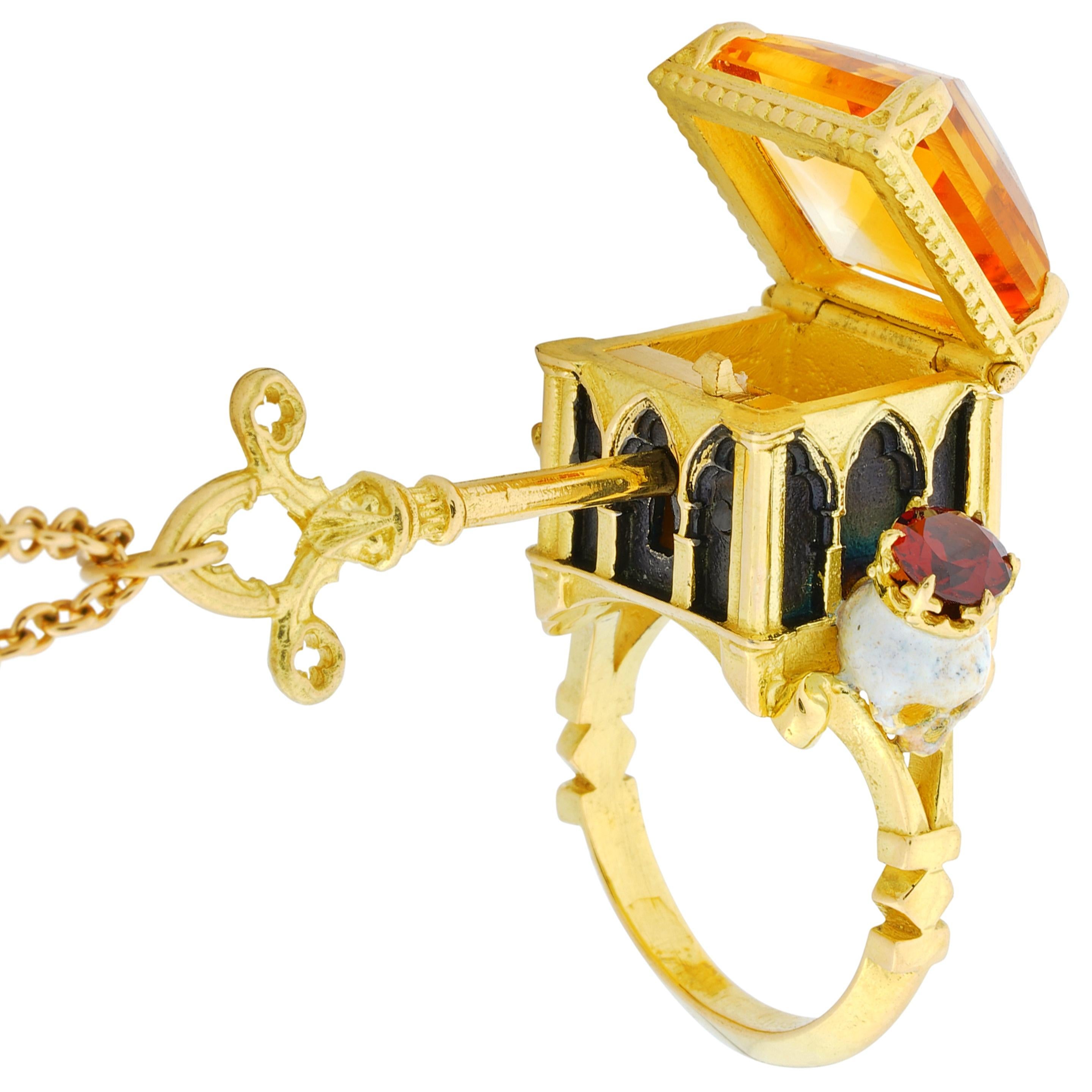 The Catacomb Saints Poison Chamber Ring is a lockable poison-ring which comes with it’s own working 18kt yellow gold key measuring 32mm in length threaded on an 18kt gold 45cm (18 inch) chain to be worn around the neck.

This piece is known as a