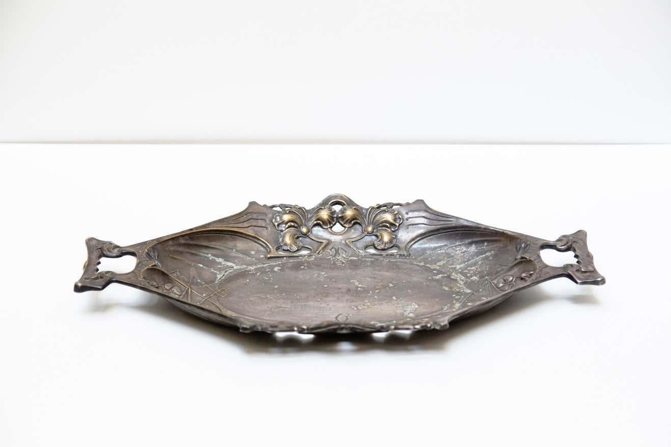 Bandeja modernista catalana de peltre de Barcelona, hacia 1930    Bandeja modernista catalana de peltre.  Fabricado en Barcelona, hacia 1930.    En su estado original, con pequeños desgastes propios de la edad y el uso, conserva una hermosa pátina. 
