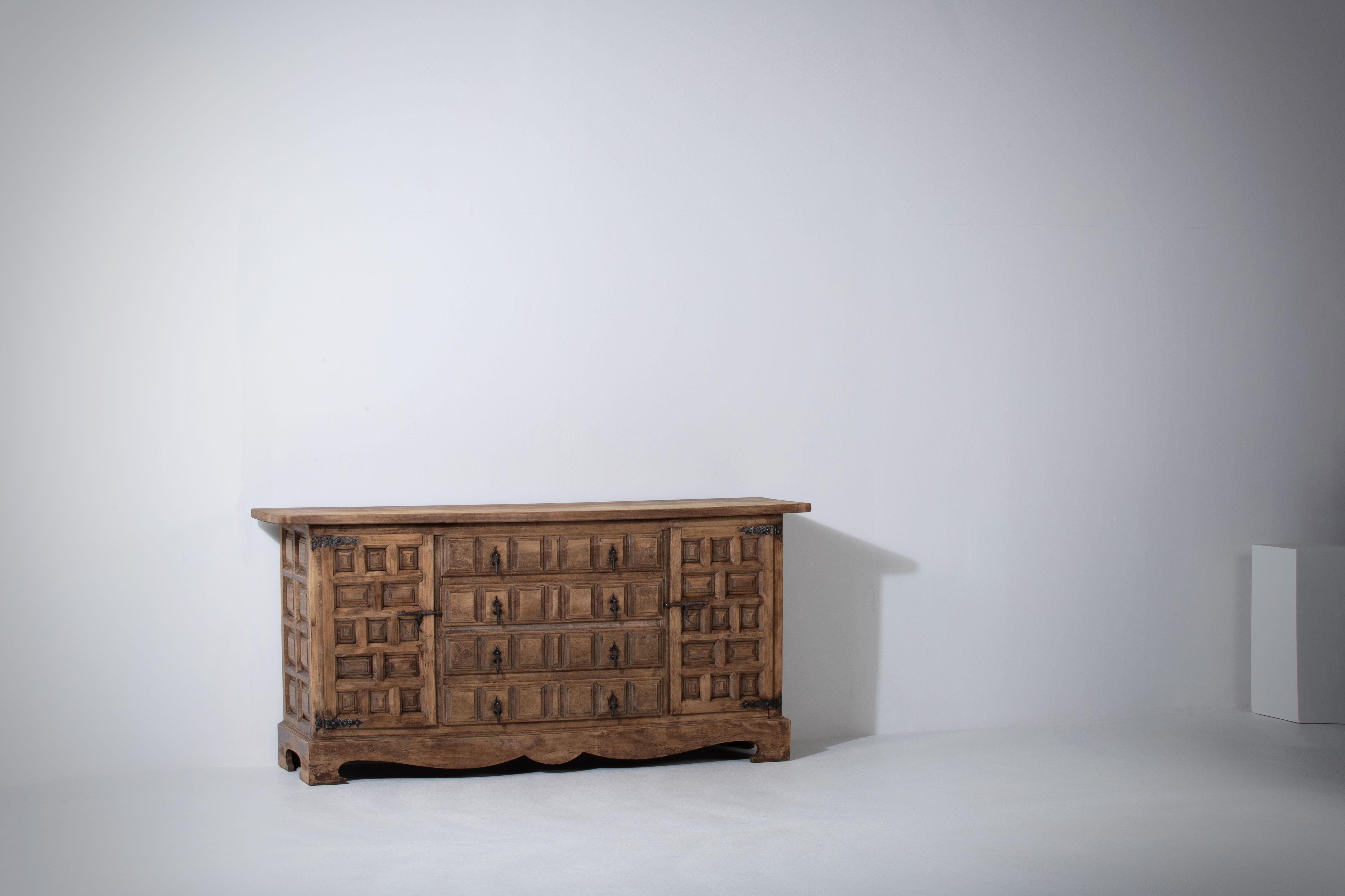 From Northern Spain, constructed of solid walnut, the rectangular top with molded edge a top a conforming case housing four drawers over four doors, the doors paneled with solid walnut, raised on a plinth base.
 