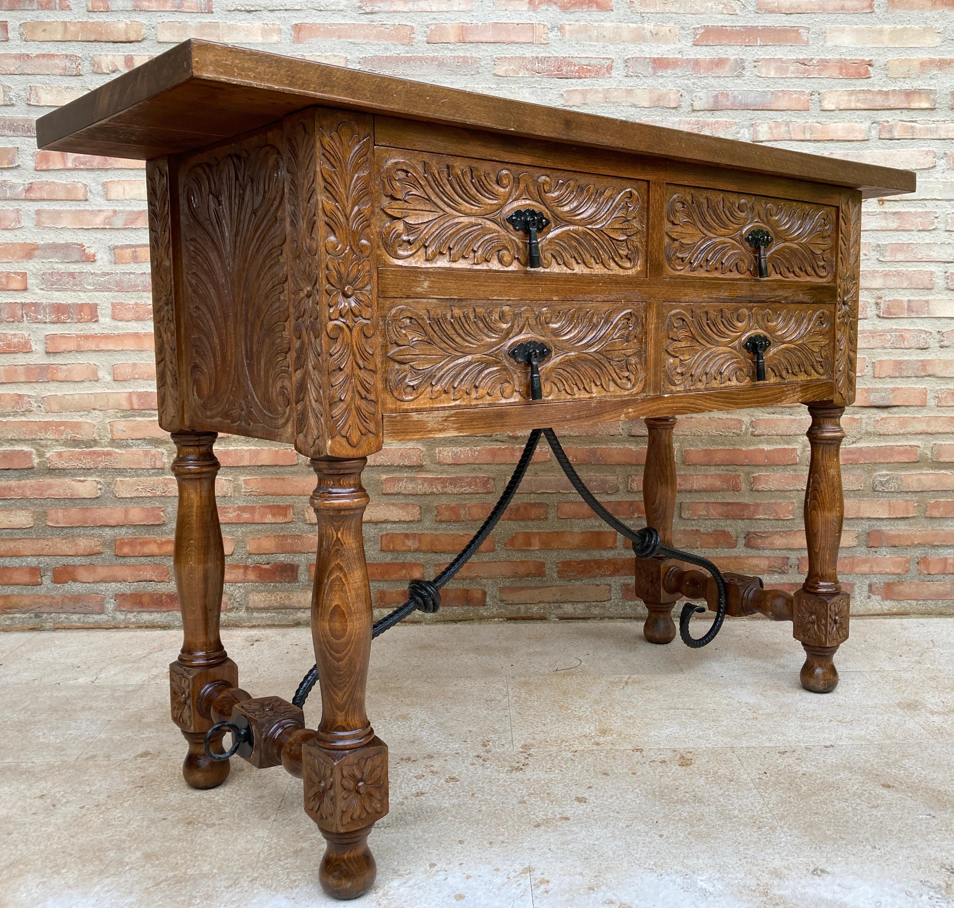 20th century Spanish carved walnut console sofa table with four drawers and iron stretcher 
You can use like a commode or chest of drawers 
This elegant antique walnut console was crafted in Spain, circa 1900. The sofa table with four legs and