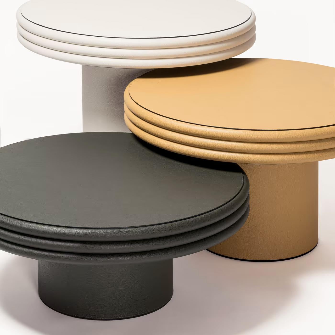 Coffee table Catane set of 3, each with solid wood structure,
covered with high quality italian genuine calfskin leather.
Black coffee table, diameter 60,5cm x height 26cm, price: 3750,00€.
Mustard coffee table, diameter 60,5cm x height 36cm,