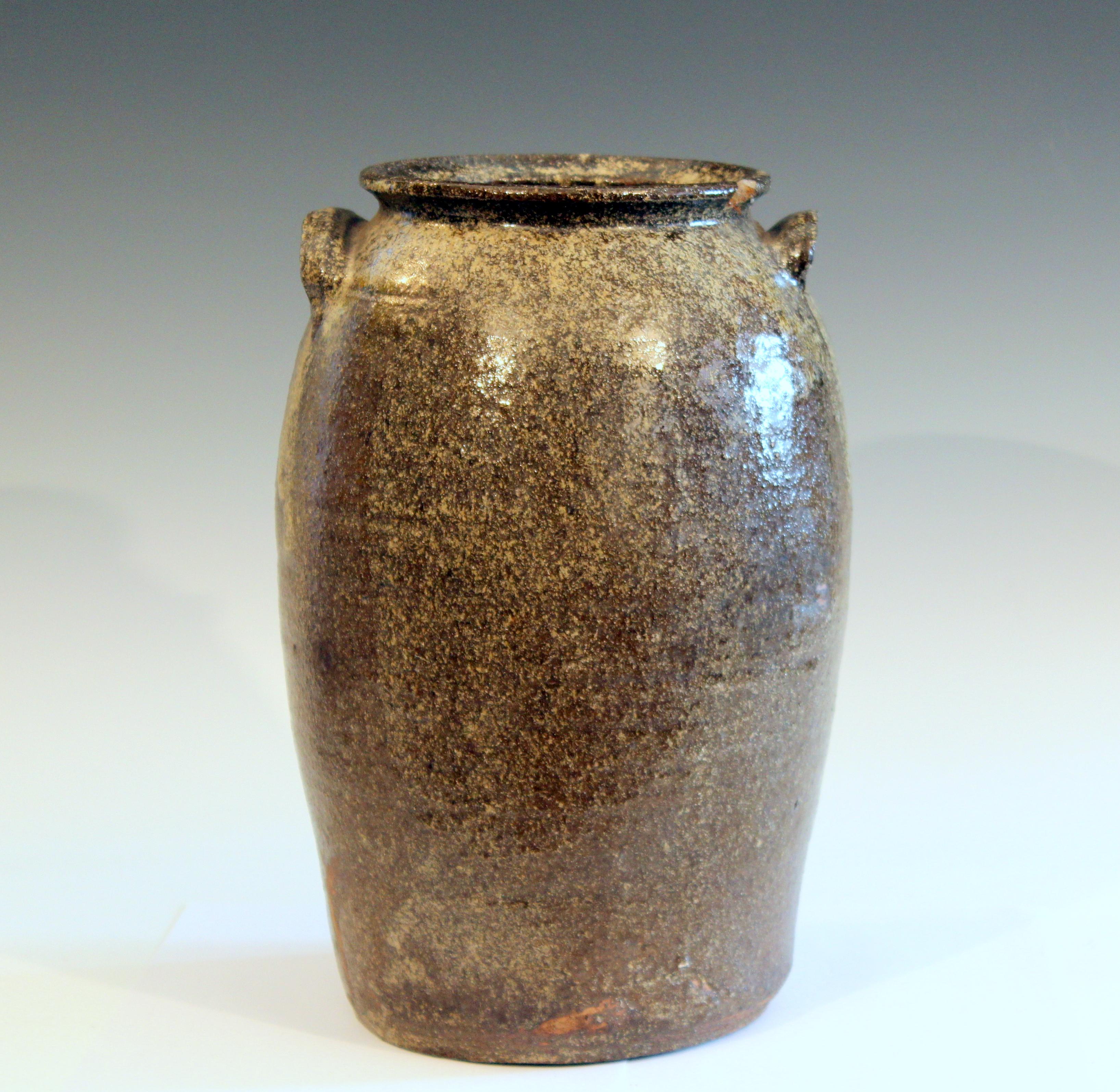 Antique Catawba Valley NC jar with brown/green alkaline glaze, circa 19th century. Terrific lichen-like contrast to the crystalline glaze with hints of blue flambe at the edges of some of the drips. 13 1/2