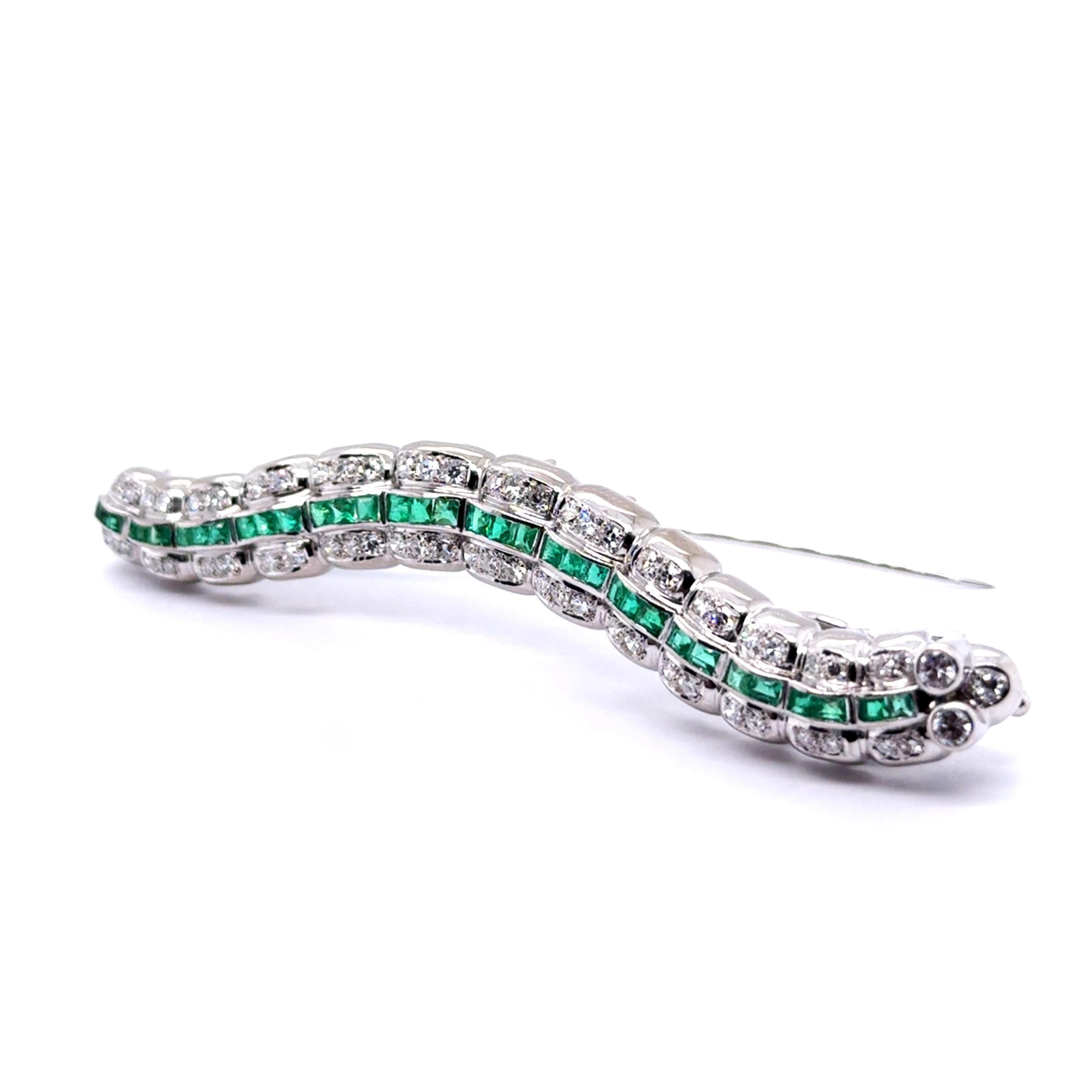 Introducing our enchanting caterpillar brooch, a masterpiece crafted in 18 Karat white gold, as if nature itself brought it to life. 

Adorned with 19 square-cut emeralds totaling 0.36 carats and 40 brilliant-cut diamonds totaling 0.80 carats, this