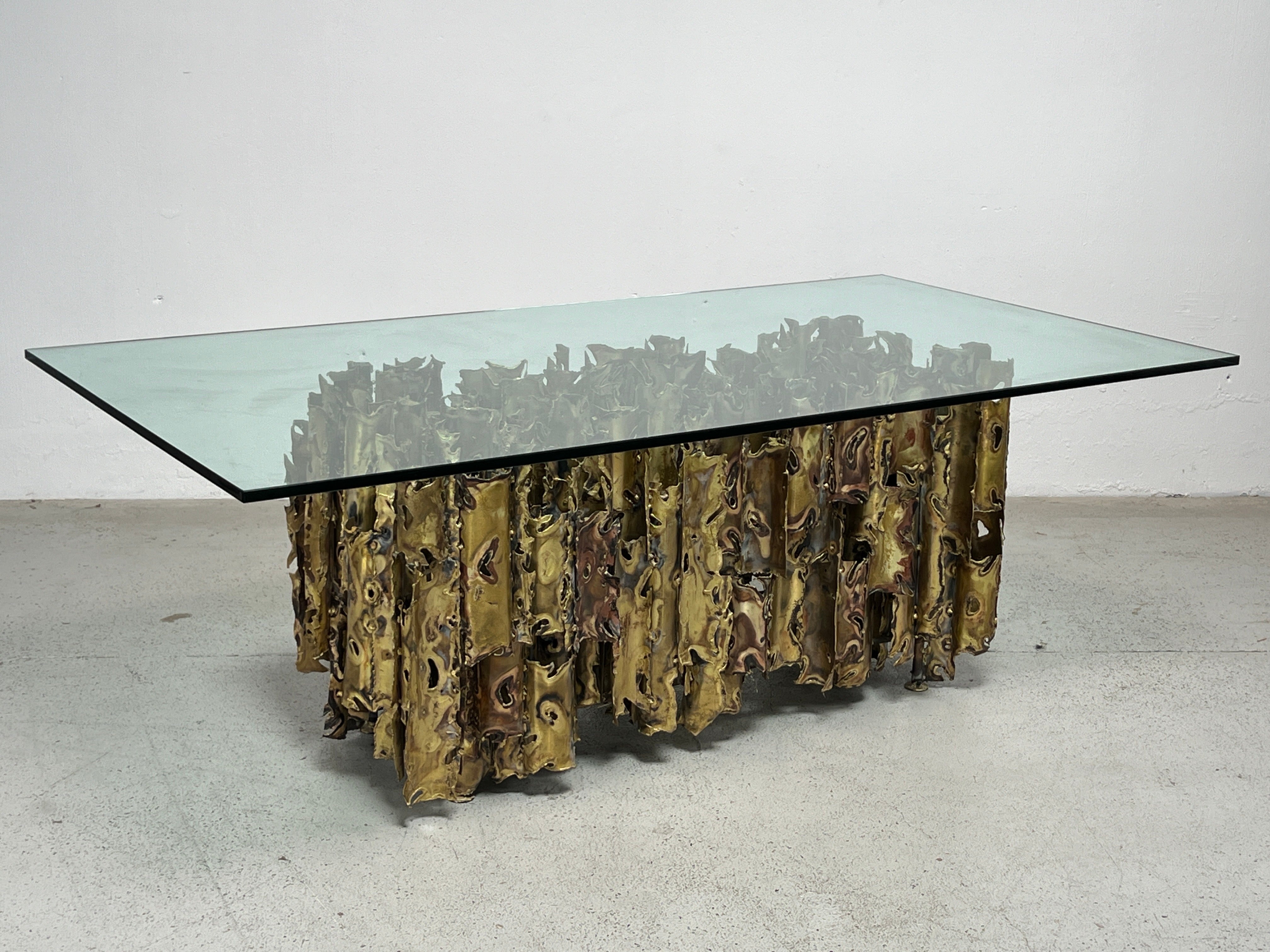 A large scale sculpted and torch cut brass 'Cathedral' dining table by Silas Seandel. Sold with copy of the original purchase order from 1978. 

Base measures 54 x 24 x 29