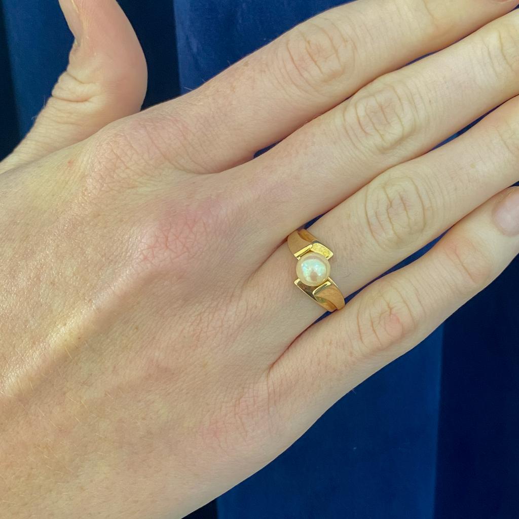 This sleek solitaire pearl ring pops with a gorgeous style. The gold setting gracefully sweeps up to flank the pearl, while the band flares on mirrored sides to create a bypass look that draws the eye once again to the smoothly rounded cultured