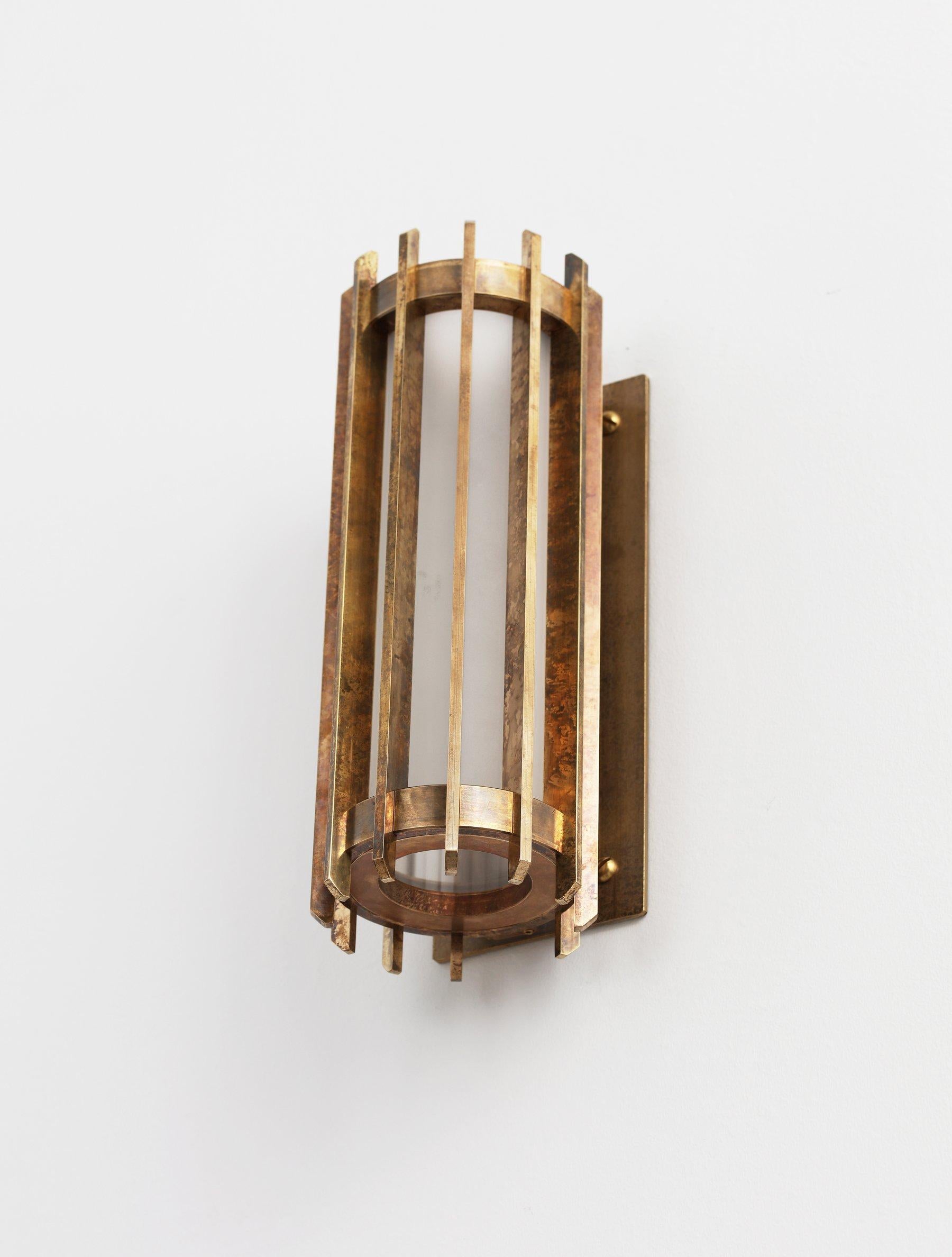 Cathedral is a contemporary representation of the Classic outdoor lantern. Milled solid-brass rings hold a frosted glass cylinder and linear brass slots diffuse the powerful light source. When viewing up close, the lamp is concealed in a way to