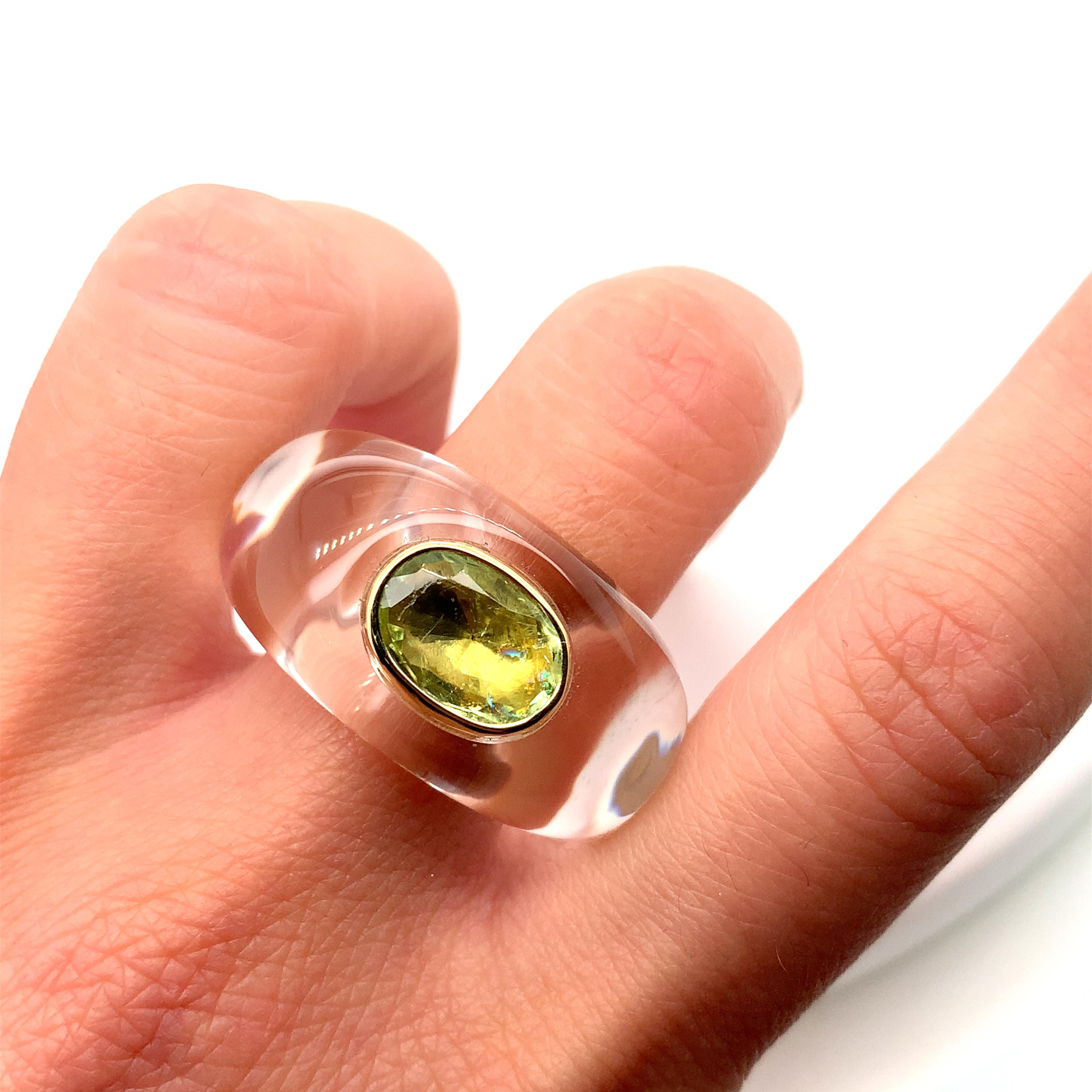 This Catherine Prevost Palm Beach London famous designer ring features a stunning 18k yellow gold and opalescent crystal solitaire setting with a beautiful oval-shaped peridot gemstone in opalescent crystal in a chunky design. The ring is adorned