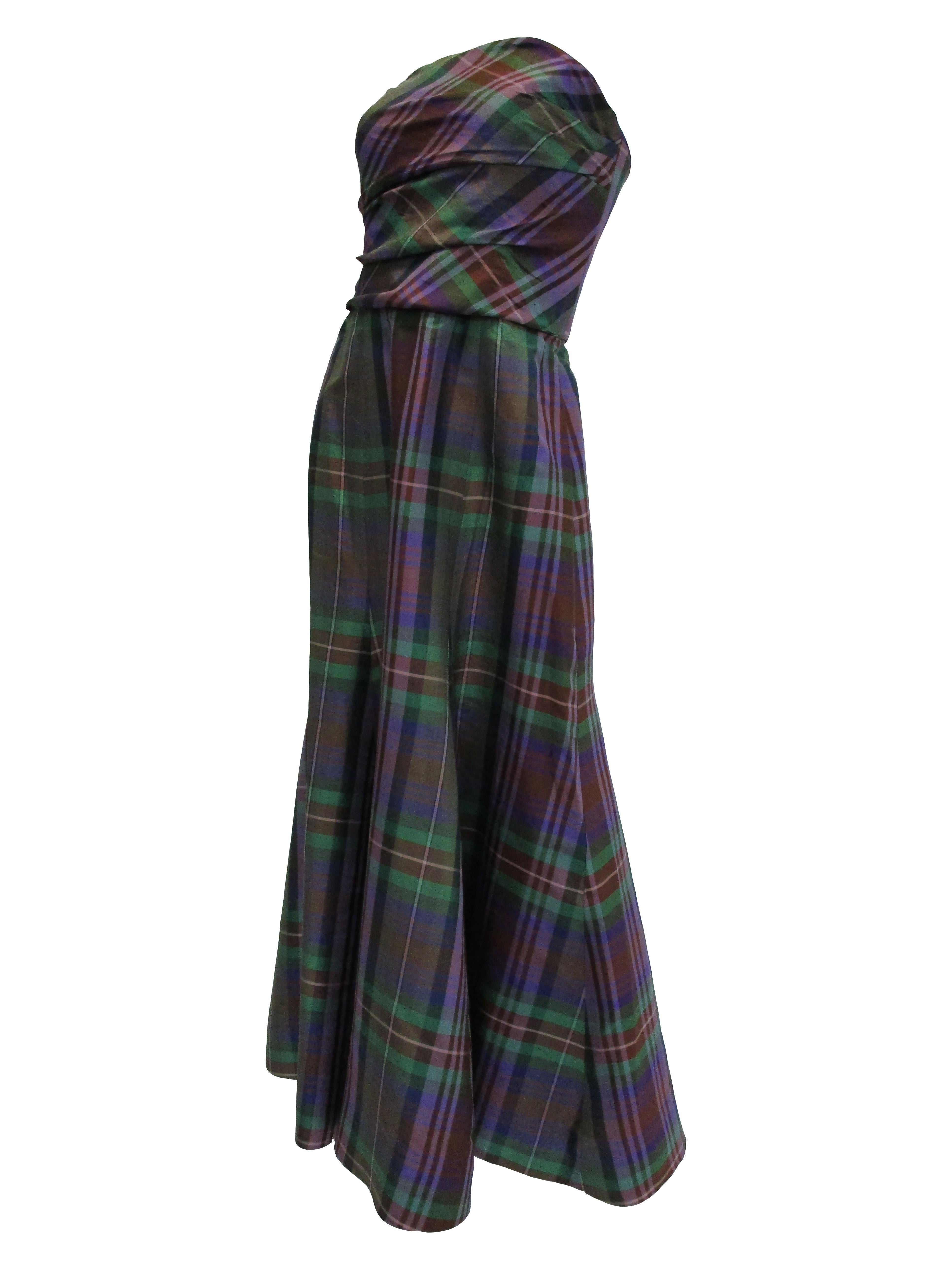 
Captivating evening gown by Catherine Regehr. The fabric is a beautiful satin plaid that gives an iridescent effect in sunlight! the dress fits snug as it wraps around the bodice and releases into an A-Line silhouette. It features a long scarf that