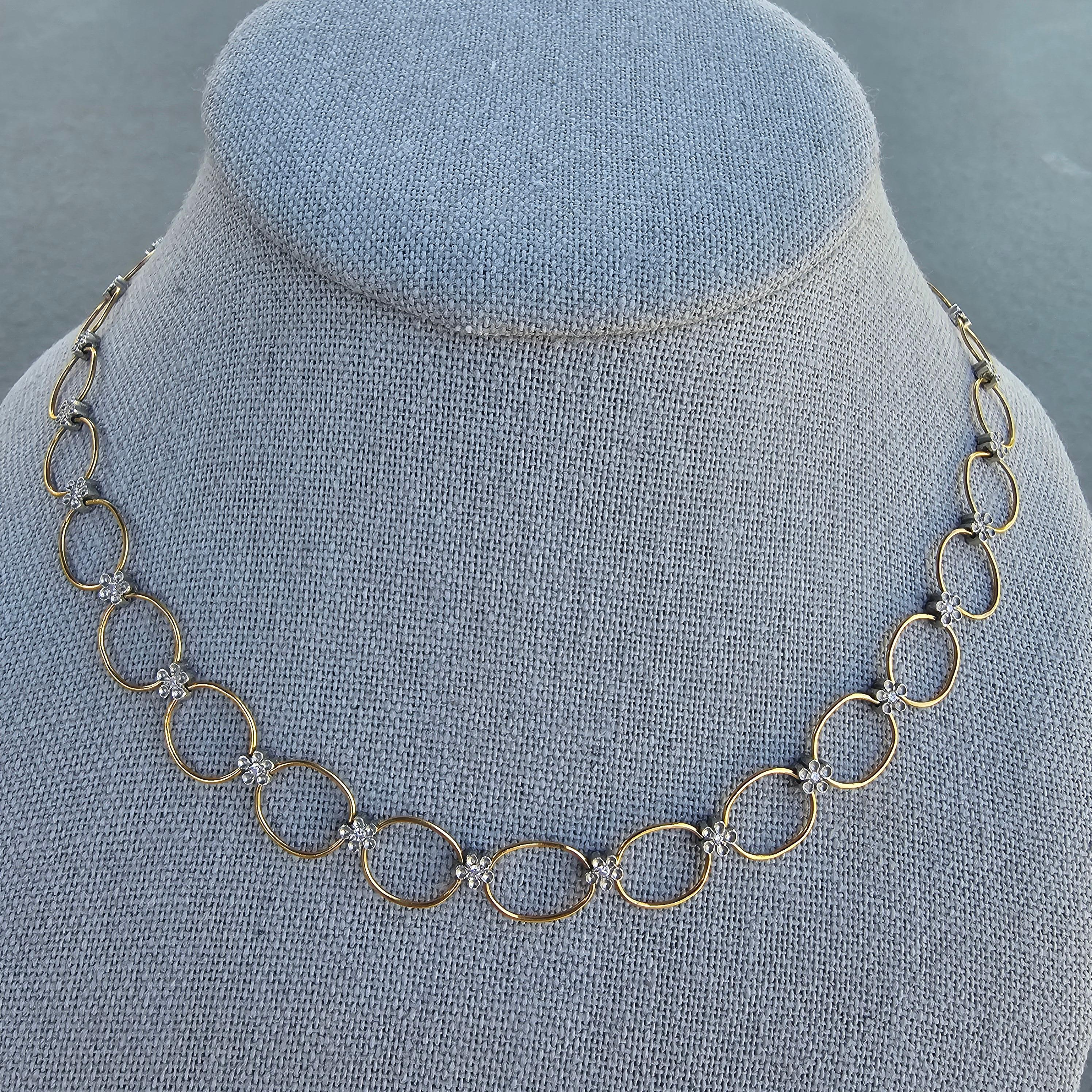Este exquisito collar gargantilla es imprescindible para cualquier entusiasta de la joyería. Realizado por Cathy Waterman, presenta una serie de eslabones ovalados de oro de 22 quilates con diamantes blancos, cada uno engastado en un delicado motivo