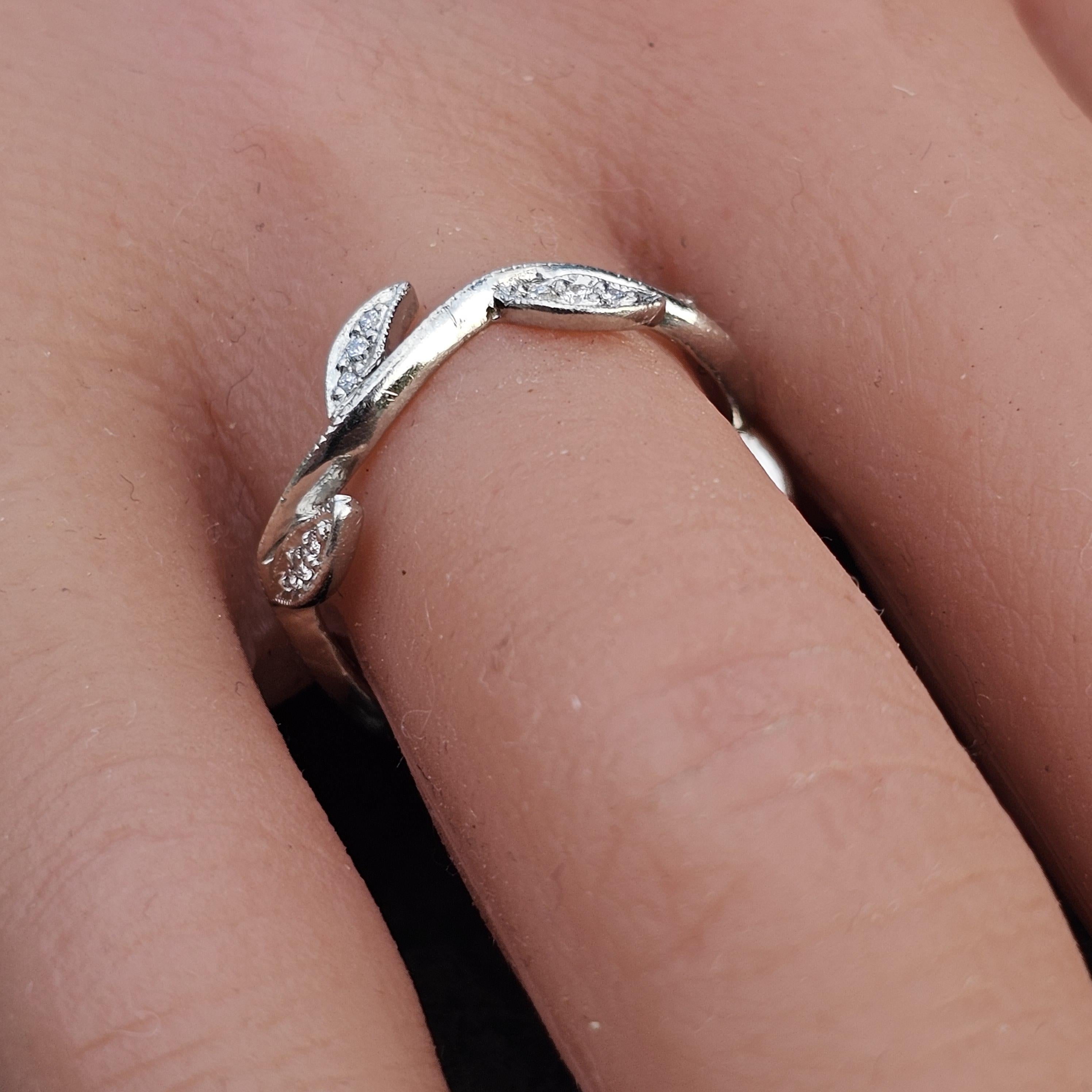 This elegant band ring is a stunning creation by Cathy Waterman. Crafted from platinum, it features a delicate vine design adorned with white diamonds. The intricate leaves and twisting branches create a natural, organic motif. The ring is a size