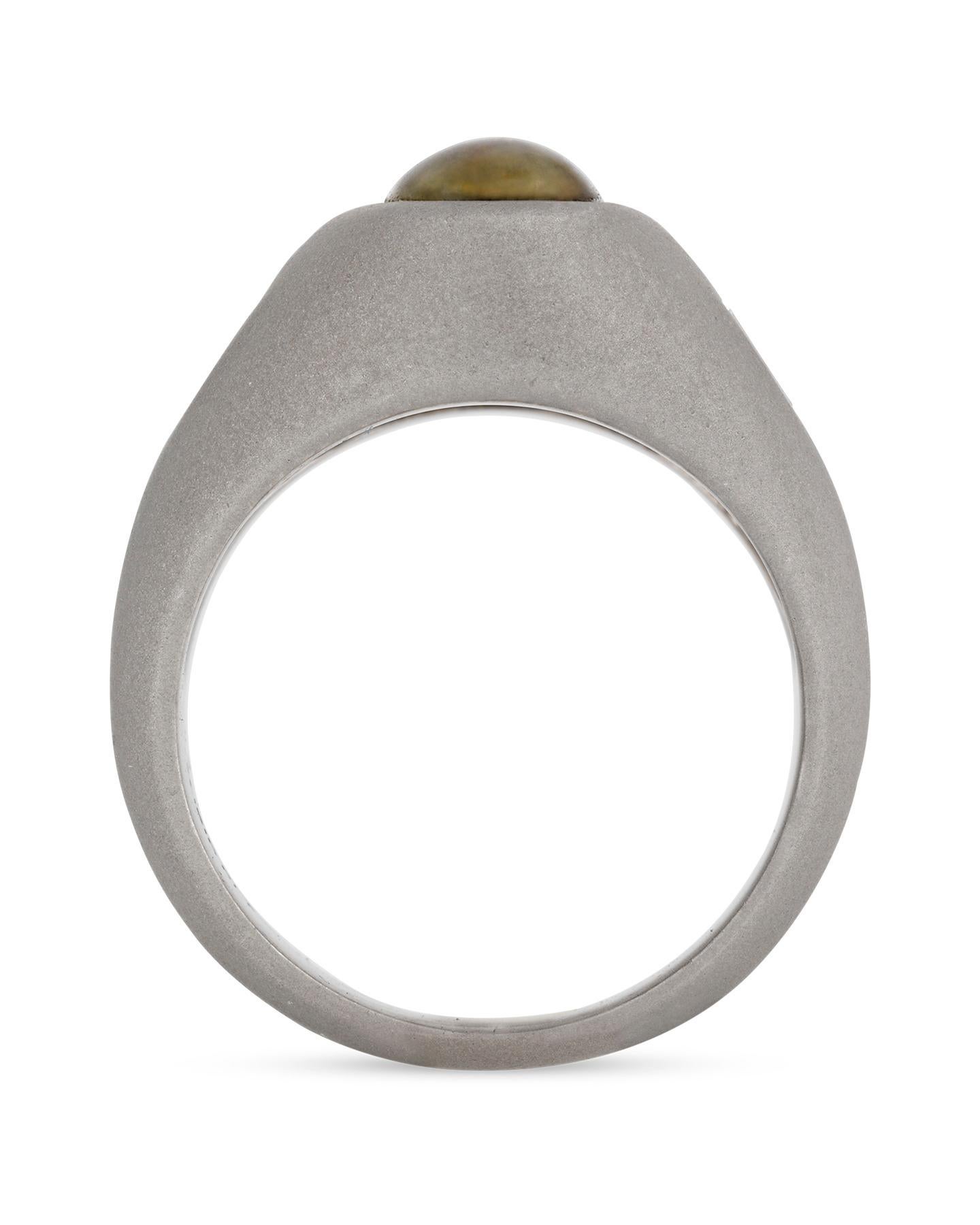 Im Mittelpunkt dieses hübschen Rings steht ein ovaler Chrysoberyll-Cabochon mit einem Gewicht von ca. 4,61 Karat im Katzenaugen-Schliff. Zwei spitz zulaufende Diamanten im Baguetteschliff der Farbe G-H und der Reinheit VS1-VS2 flankieren jede Seite